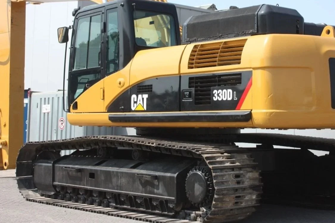 Yellow and black Caterpillar 330D hydraulic excavator with tracked undercarriage parked outdoors.