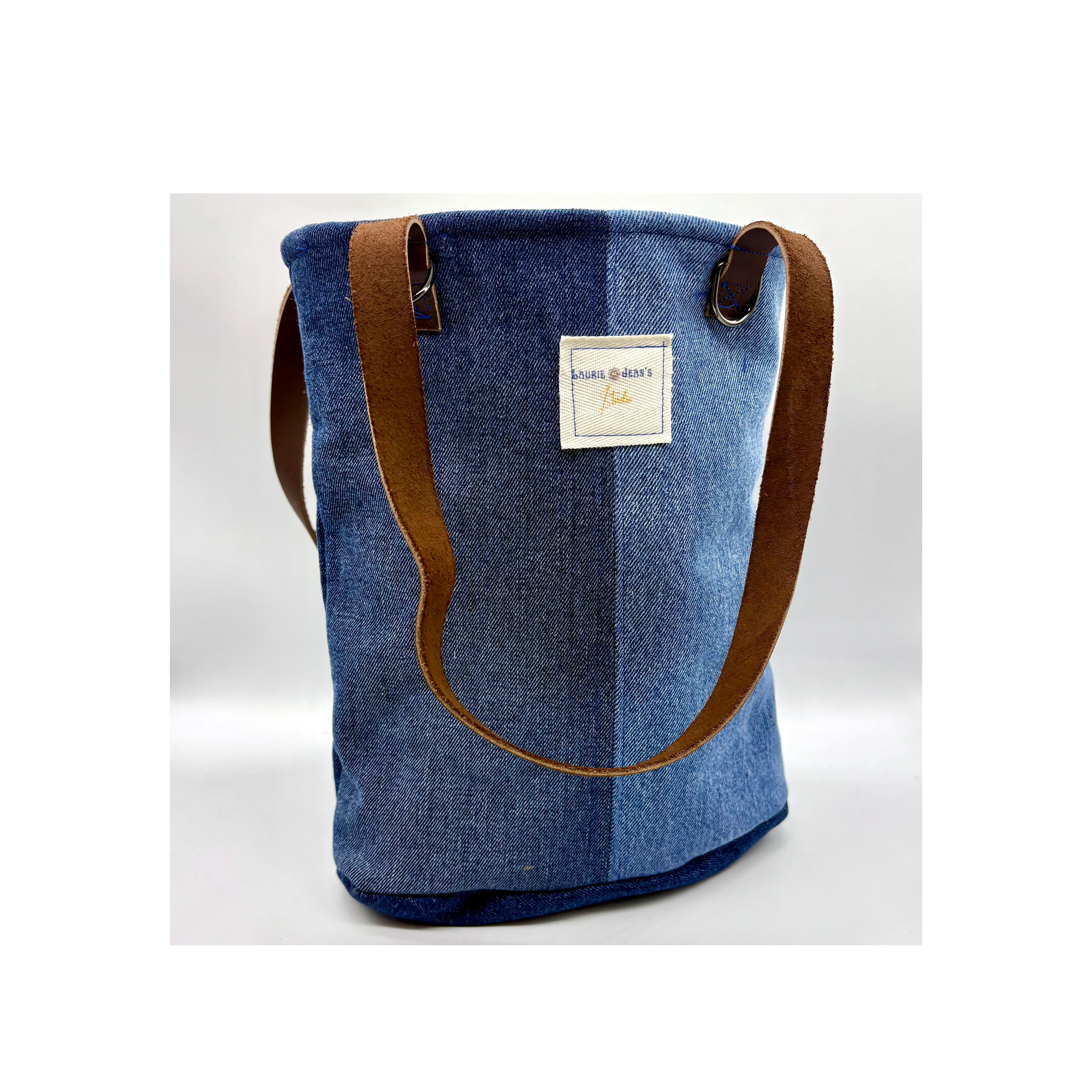 Denim two toned bucket bag featuring leather handles