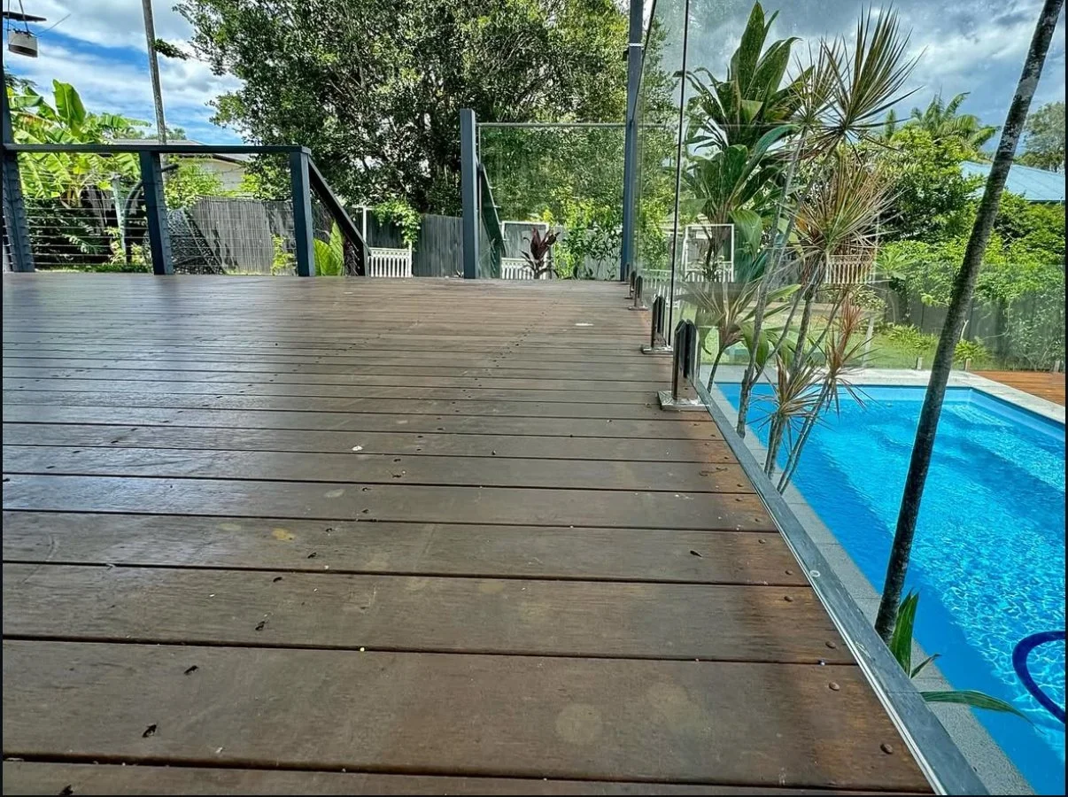 Weathered poolside deck in Brisbane before sanding, boards greyed and dull