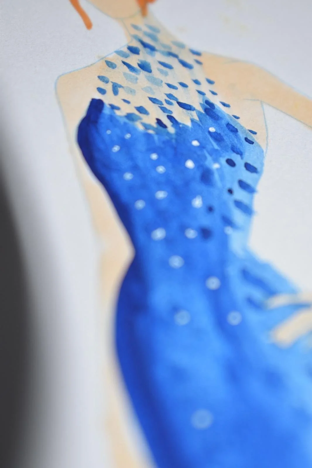 Close-up of a watercolor painting of a woman in a blue dress with white dots, viewed at an angle.