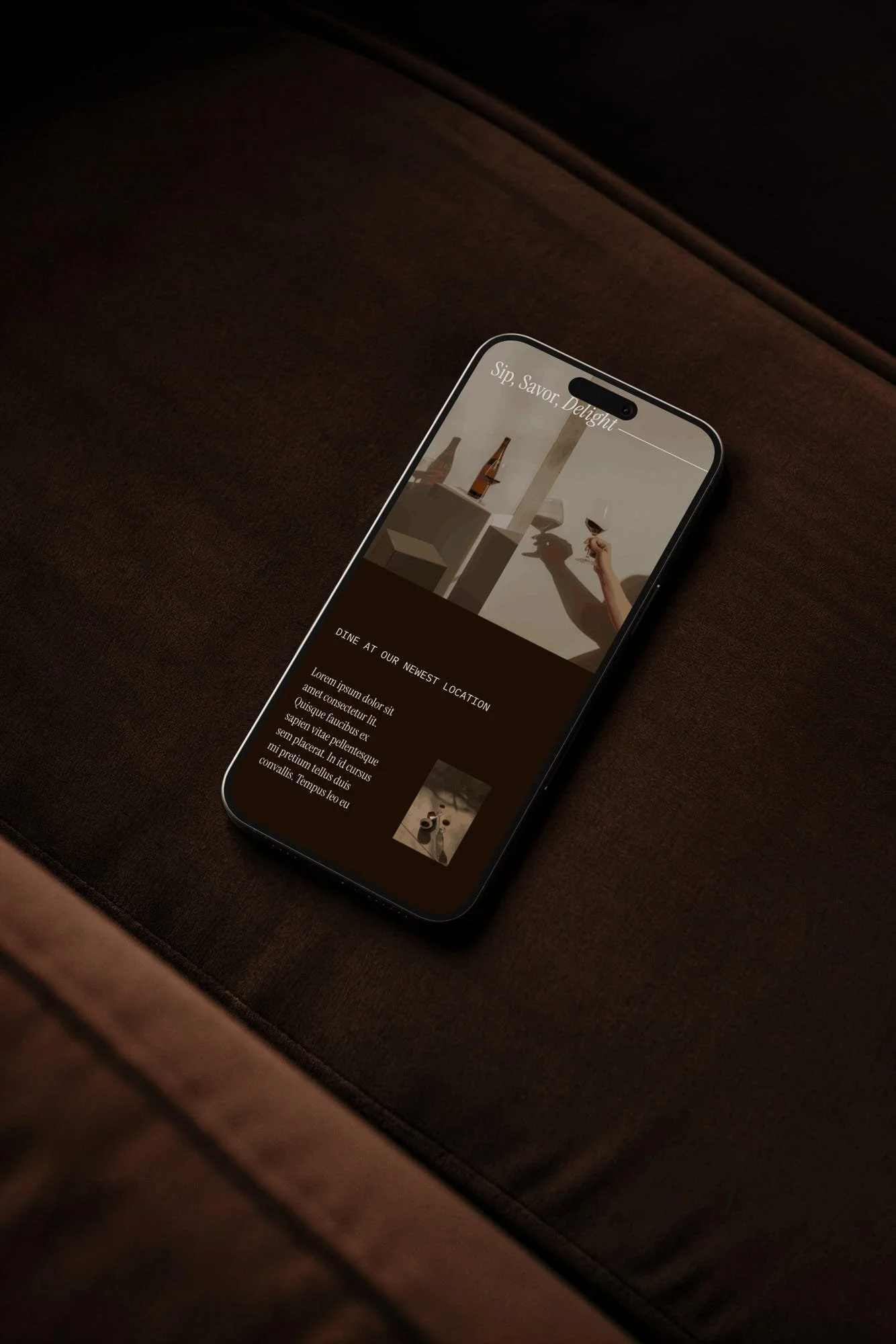 wine bar website design in Iphone mockup on dark brown couch