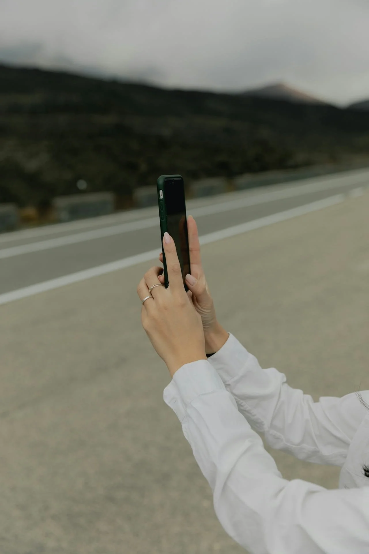 ai + seo visibility audit - woman in white shirt, one hand behind her head the other holding her phone in selfie mode