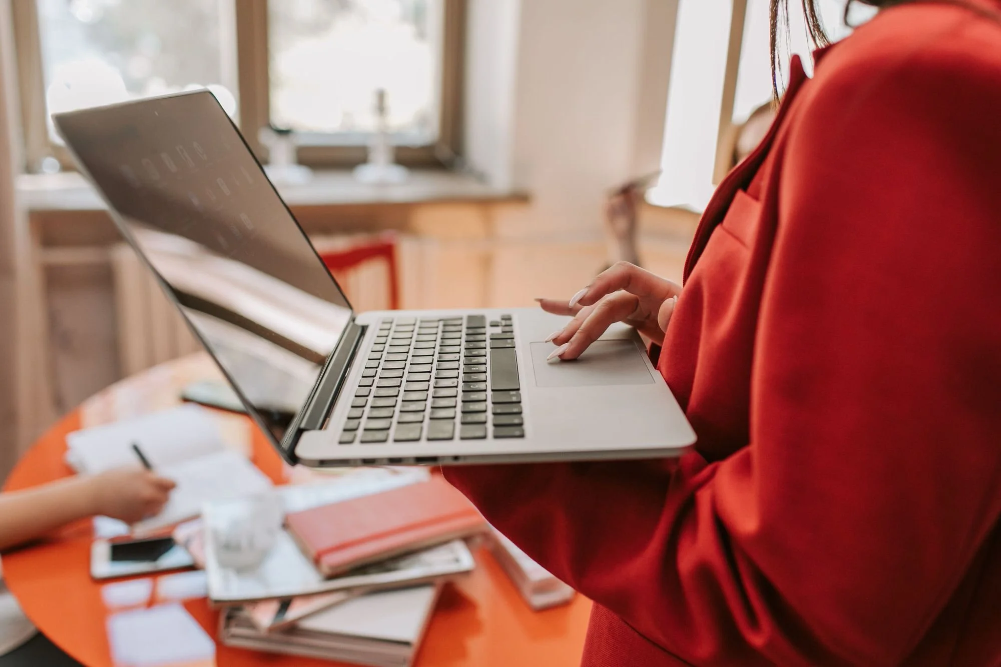 woman holding laptop and typing