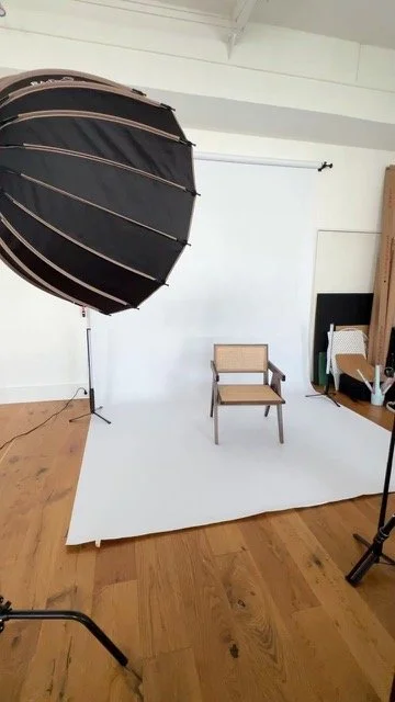 Fotostudio mit weiße Hintergrund, Sessel in der Mitte, Beleuchtung mit Schwarz und Gold, Holzfußboden.