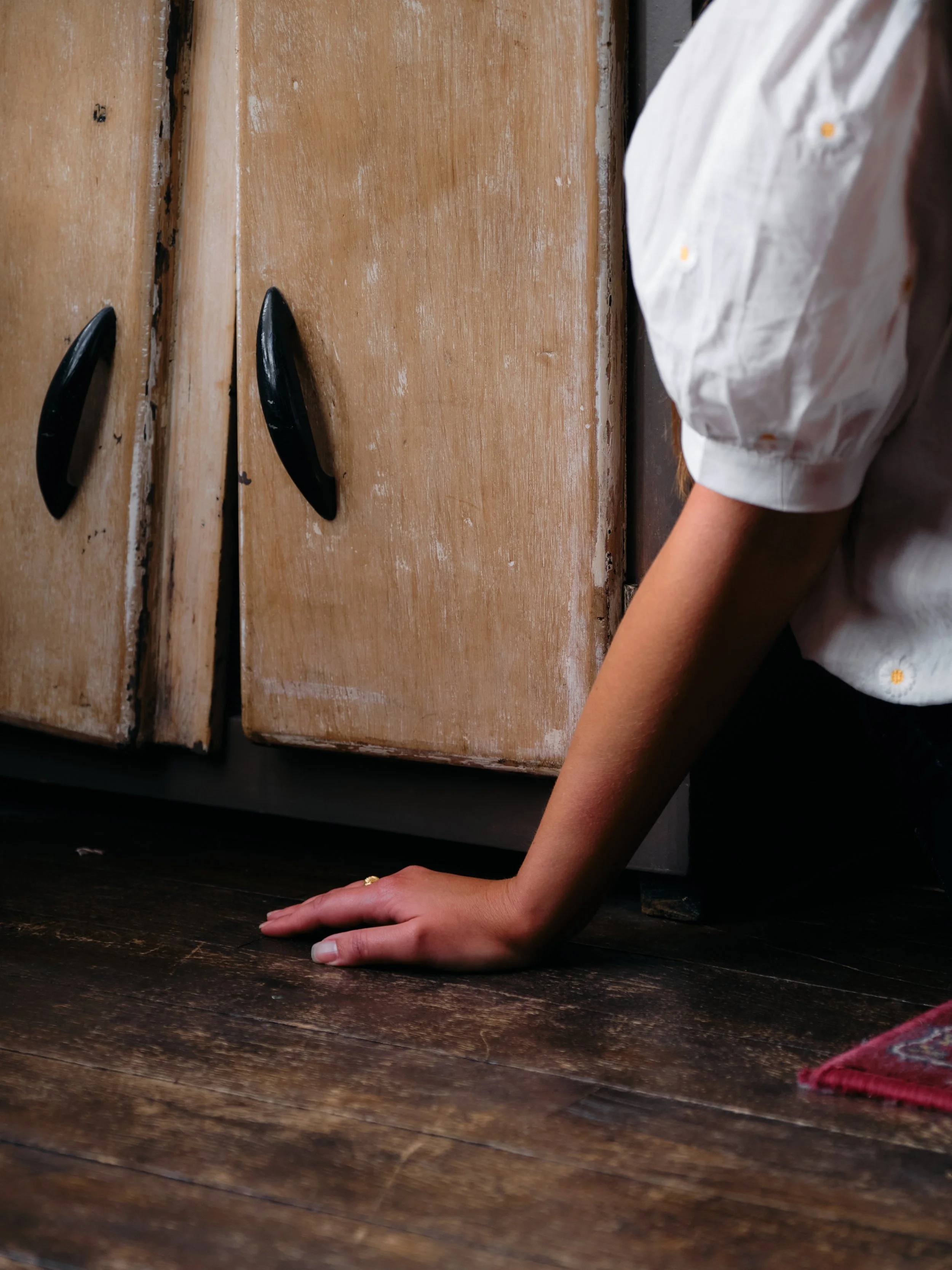 In a tiny apartment in Paris, there's a girl set on the floor. We can see just her hand.
