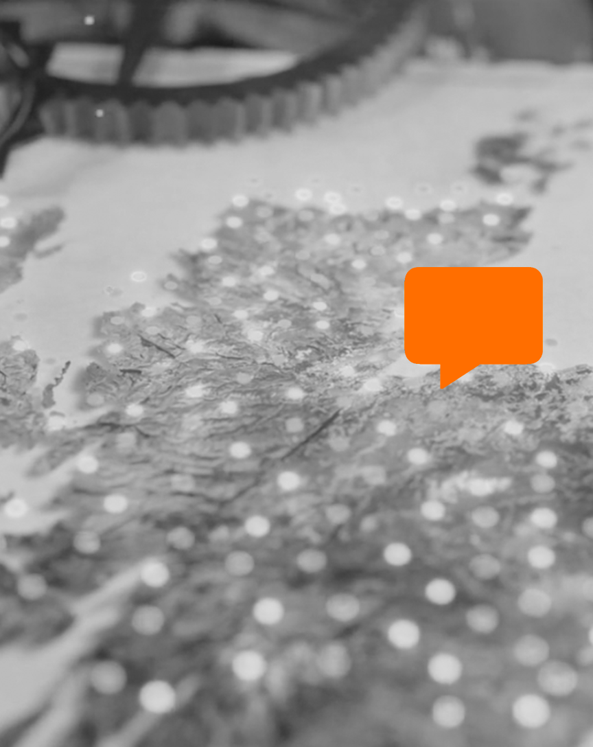 Close-up of a map with an orange speech bubble overlay, black and white photography.