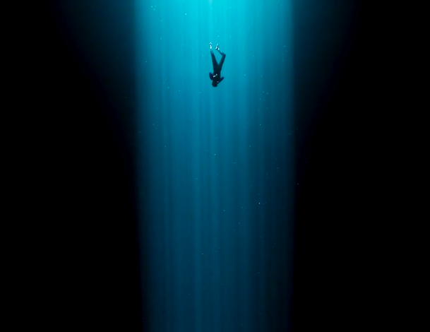 A free diver in blue light