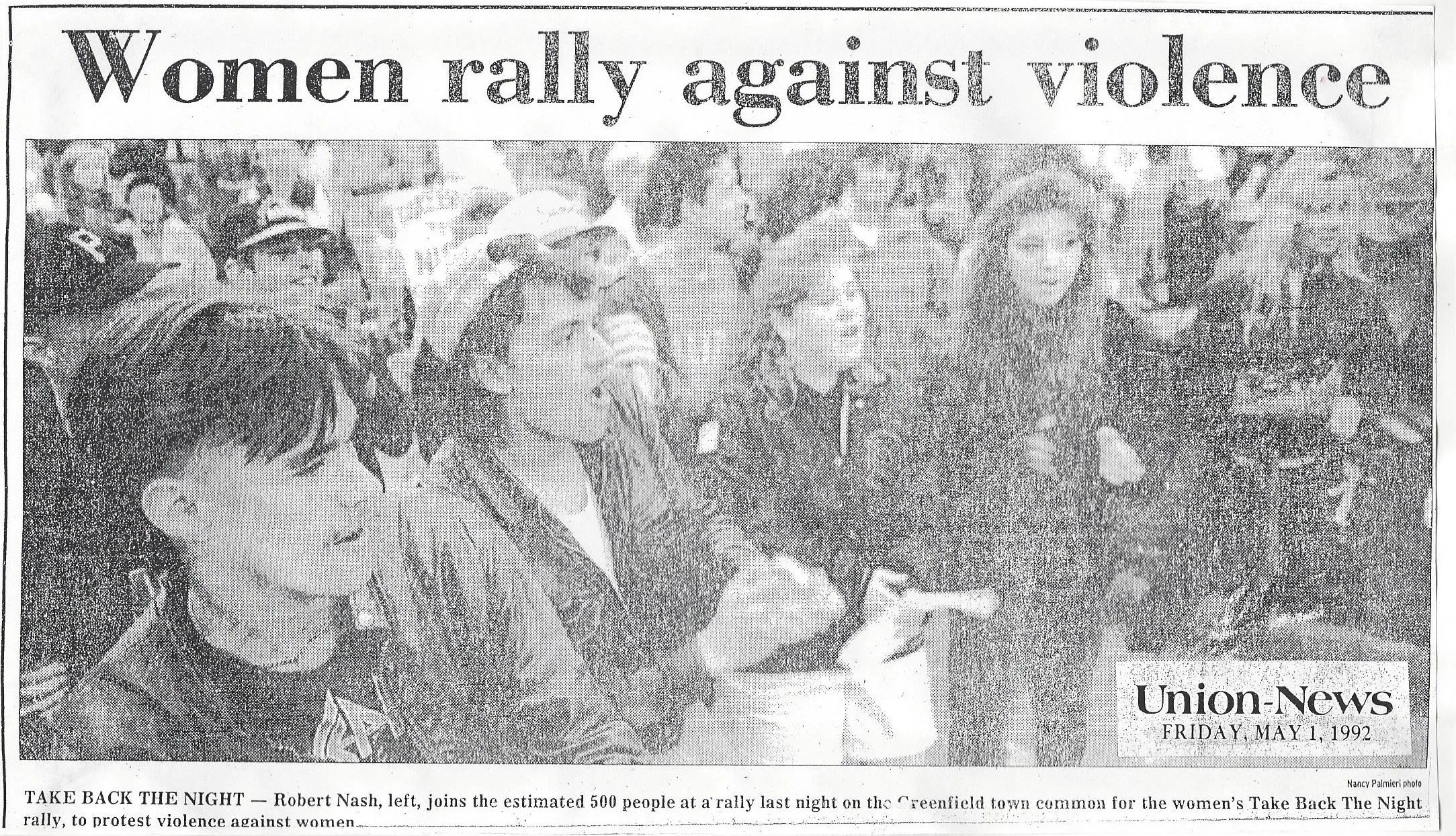 Black and white newspaper clipping with a headline, 'Women rally against violence', showing women and men gathered at a rally. The photo shows women, including Robert Nash on the left, protesting violence against women in Greenfield, dated May 1, 199