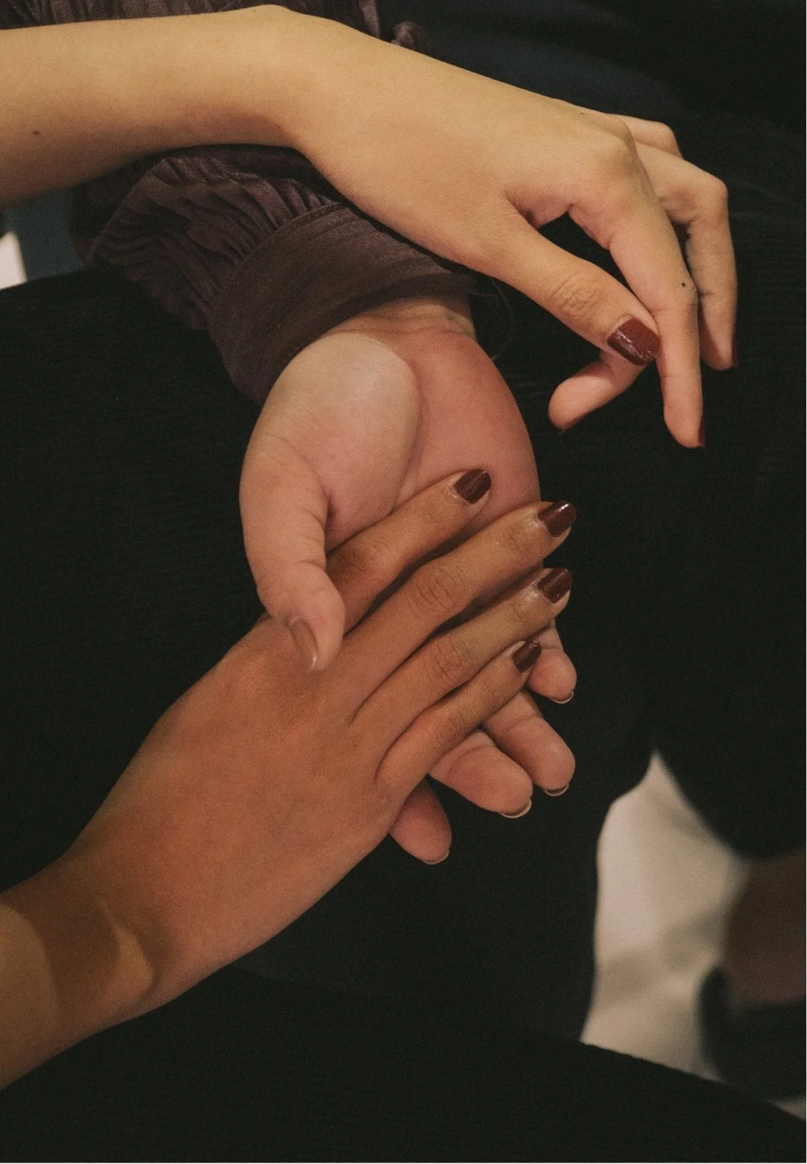 Close-up of two hands, one with painted nails, gently holding a man's hand, representing the new understanding neurodiverse couples can reach