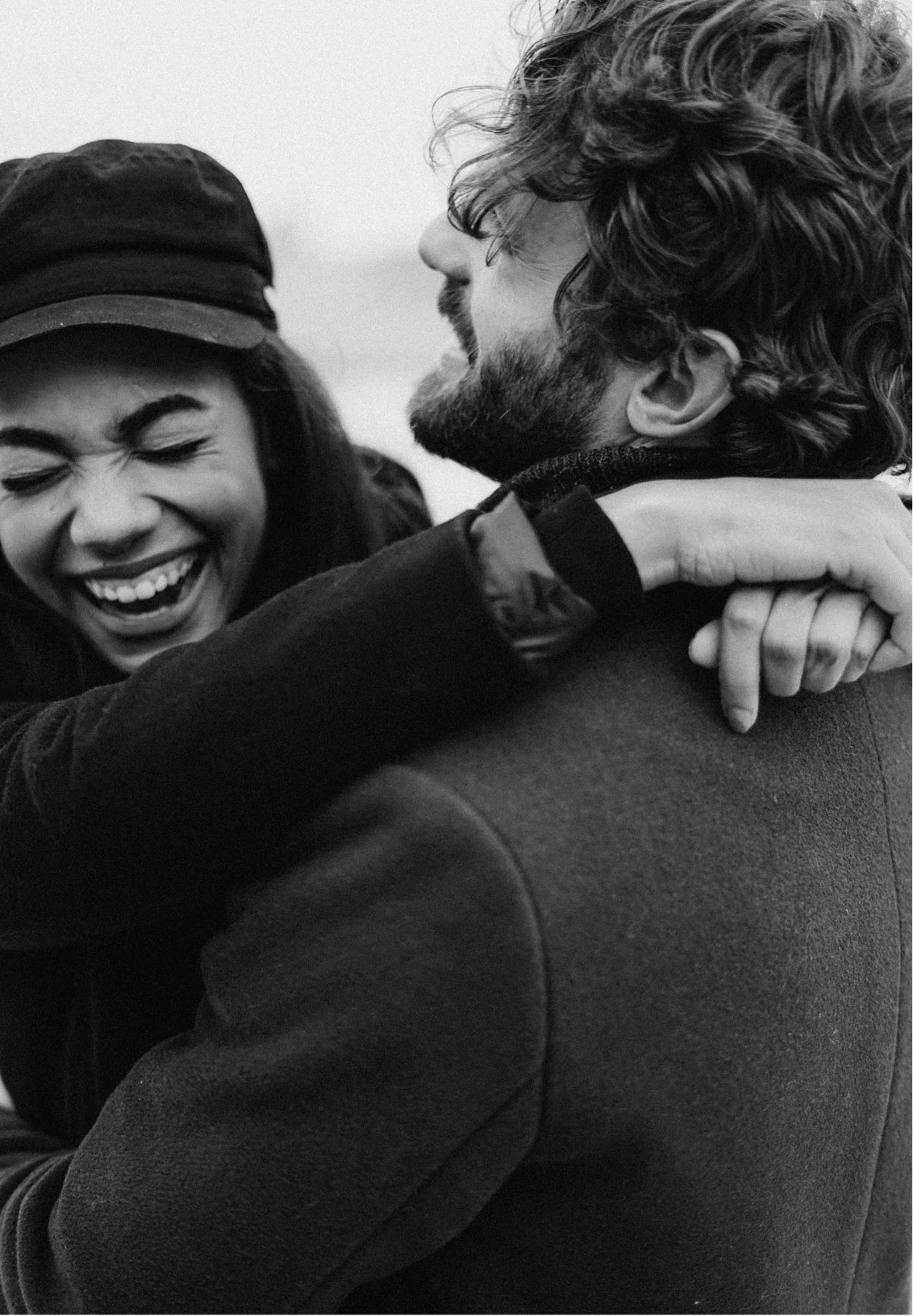 a woman and a man embracing each other, laughing, signifying a healthy relationship thanks to couples counseling