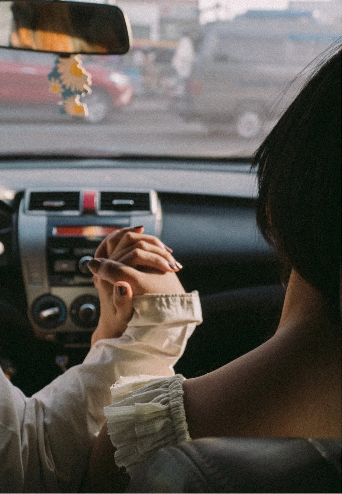 Two people holding hands inside a car, showcasing a bond they strengthened thanks to couples counseling