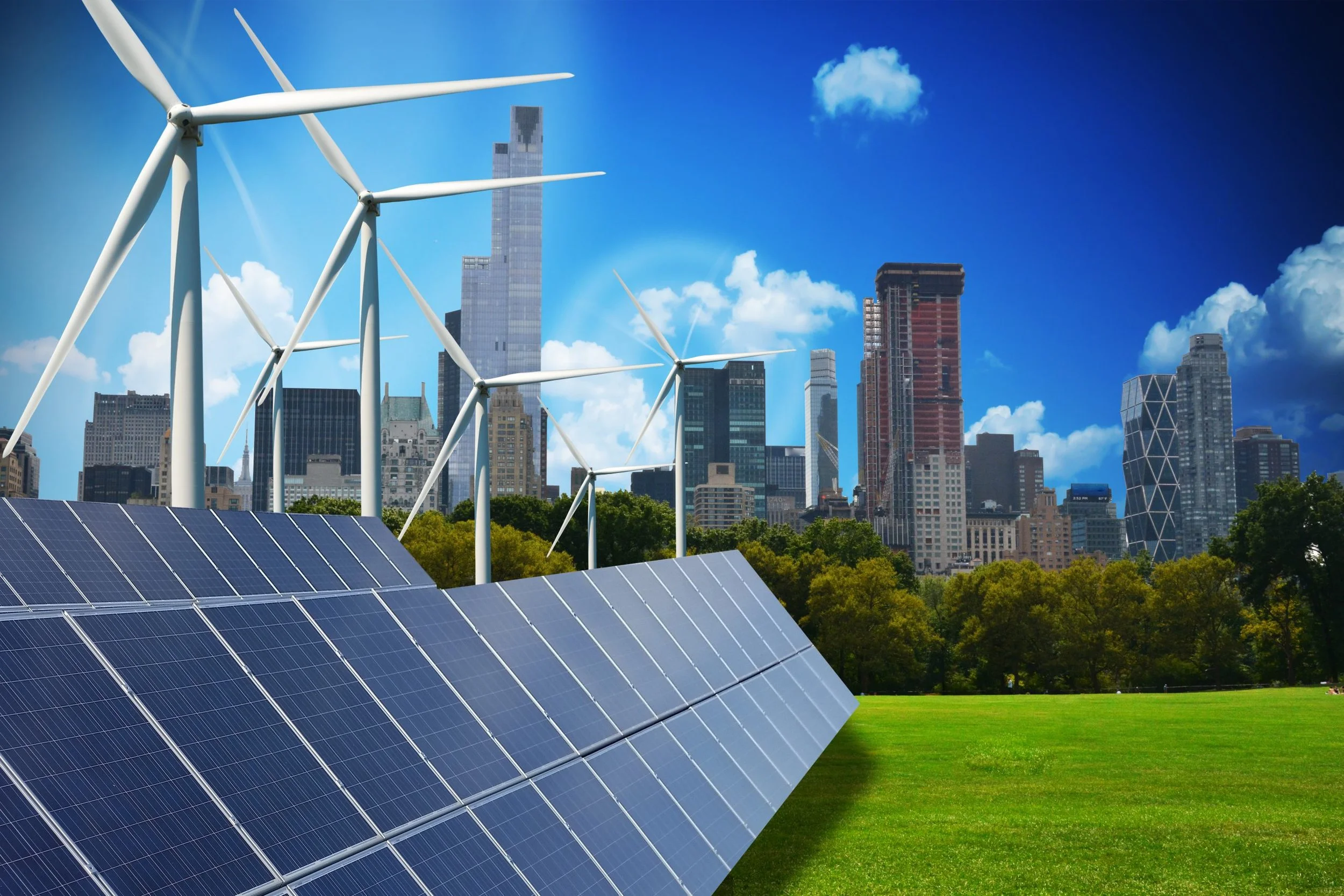 Solar panels in the foreground with wind turbines behind, set against a city skyline with tall buildings under a blue sky with clouds.