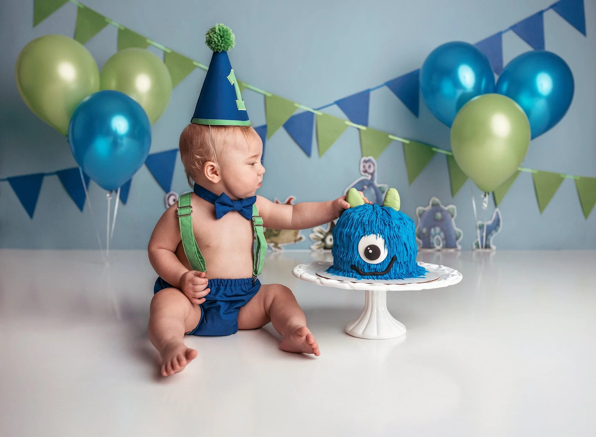 A year of monstrous fun: Baby celebrating with a Monsters Inc. cake, a colorful and joyful moment