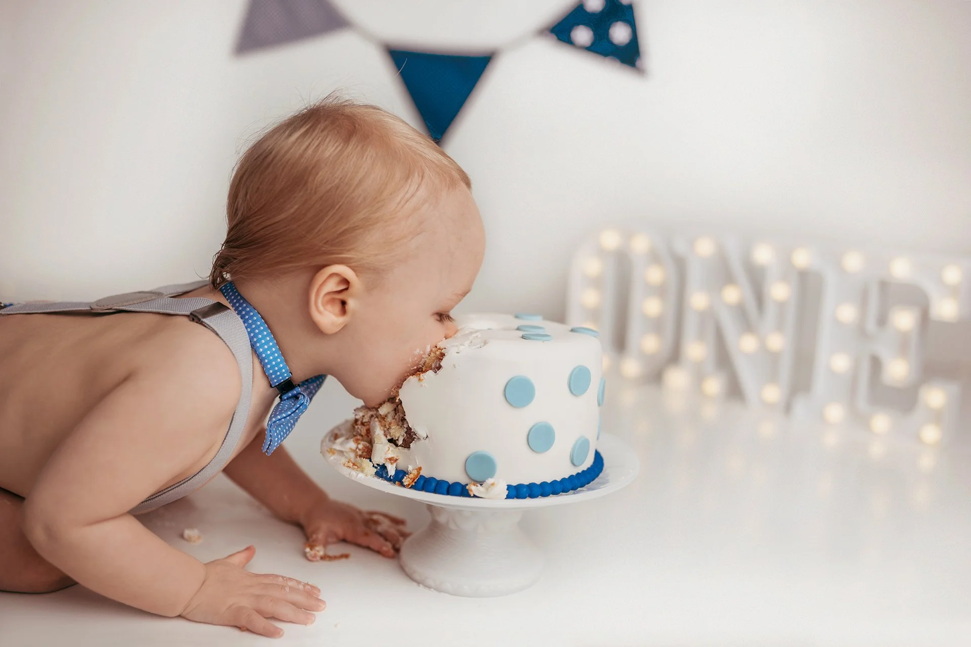 Little one's sweet dive: Baby with head in cake, a moment of pure cake smash joy