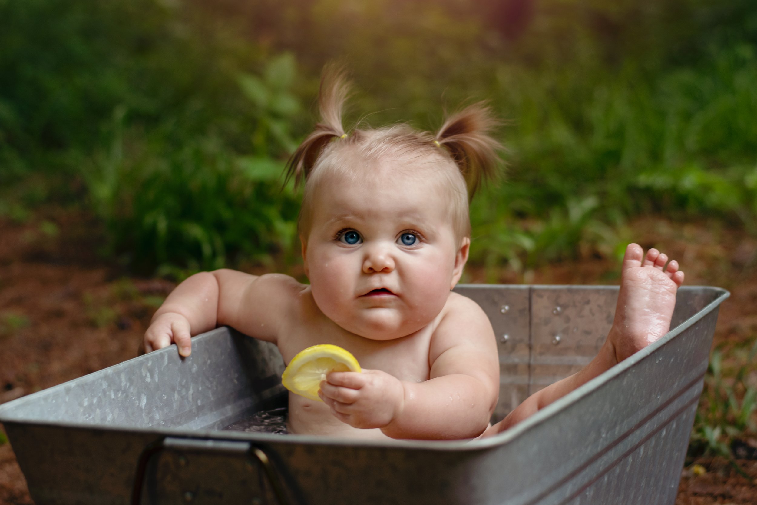Precious moment: Baby in tub with lemon, a mix of curiosity and confusion