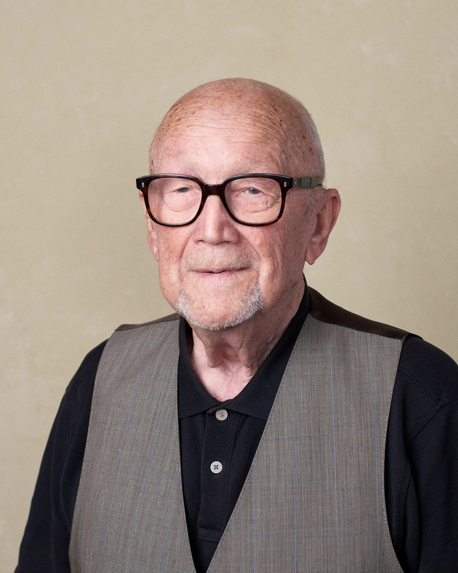 Peter Pfefferkorn mit dunkler Brille und Weste vor einem grünlich getönten Hintergrund.