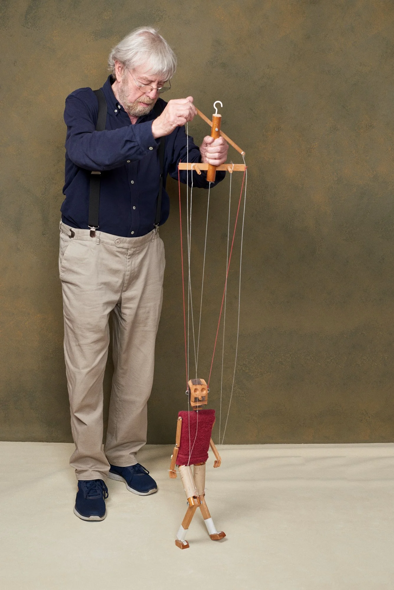 Axel Pfefferkorn führt eine Marionette und betrachtet konzentriert ihre Fäden.