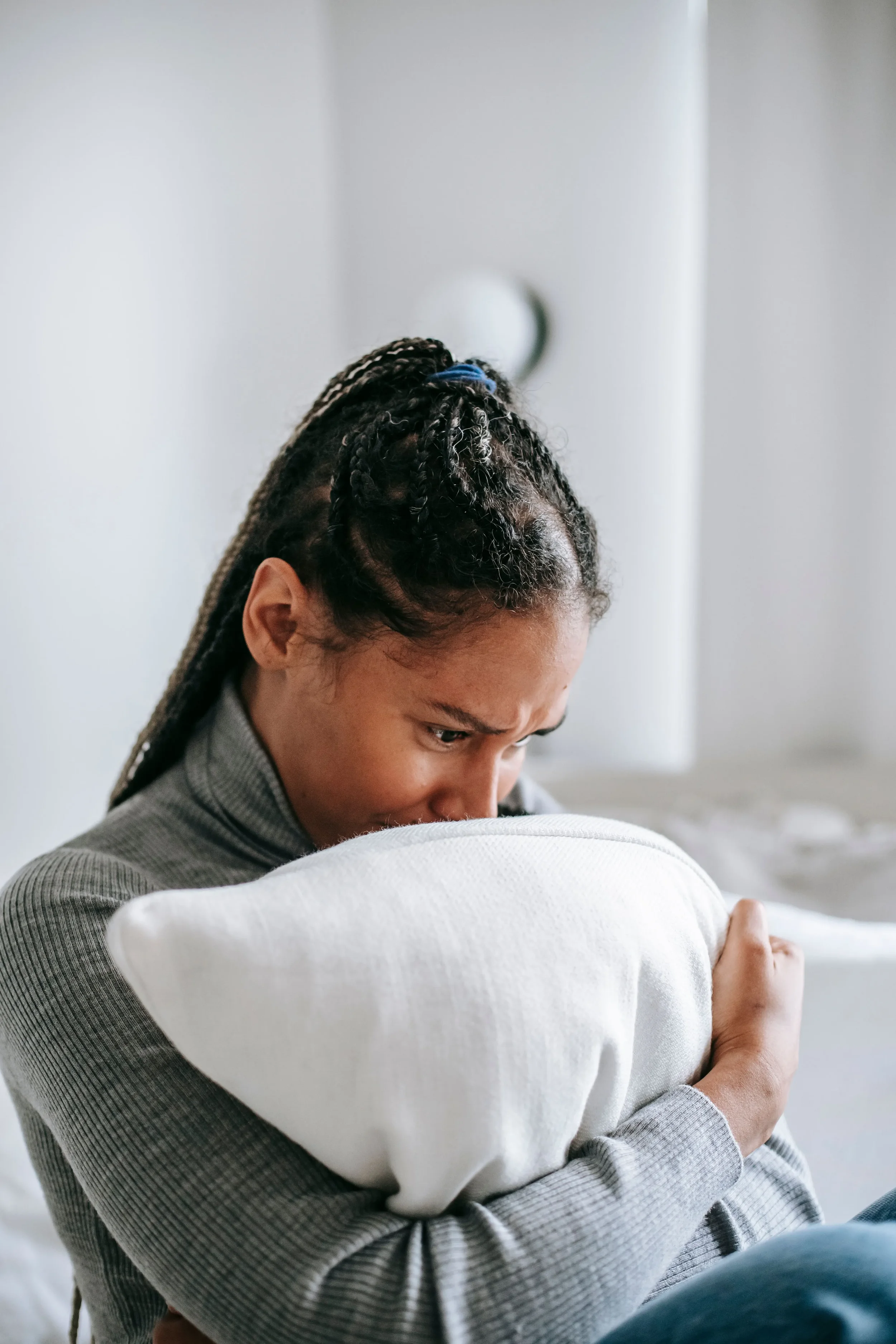 Teen holidng a pillow and crying