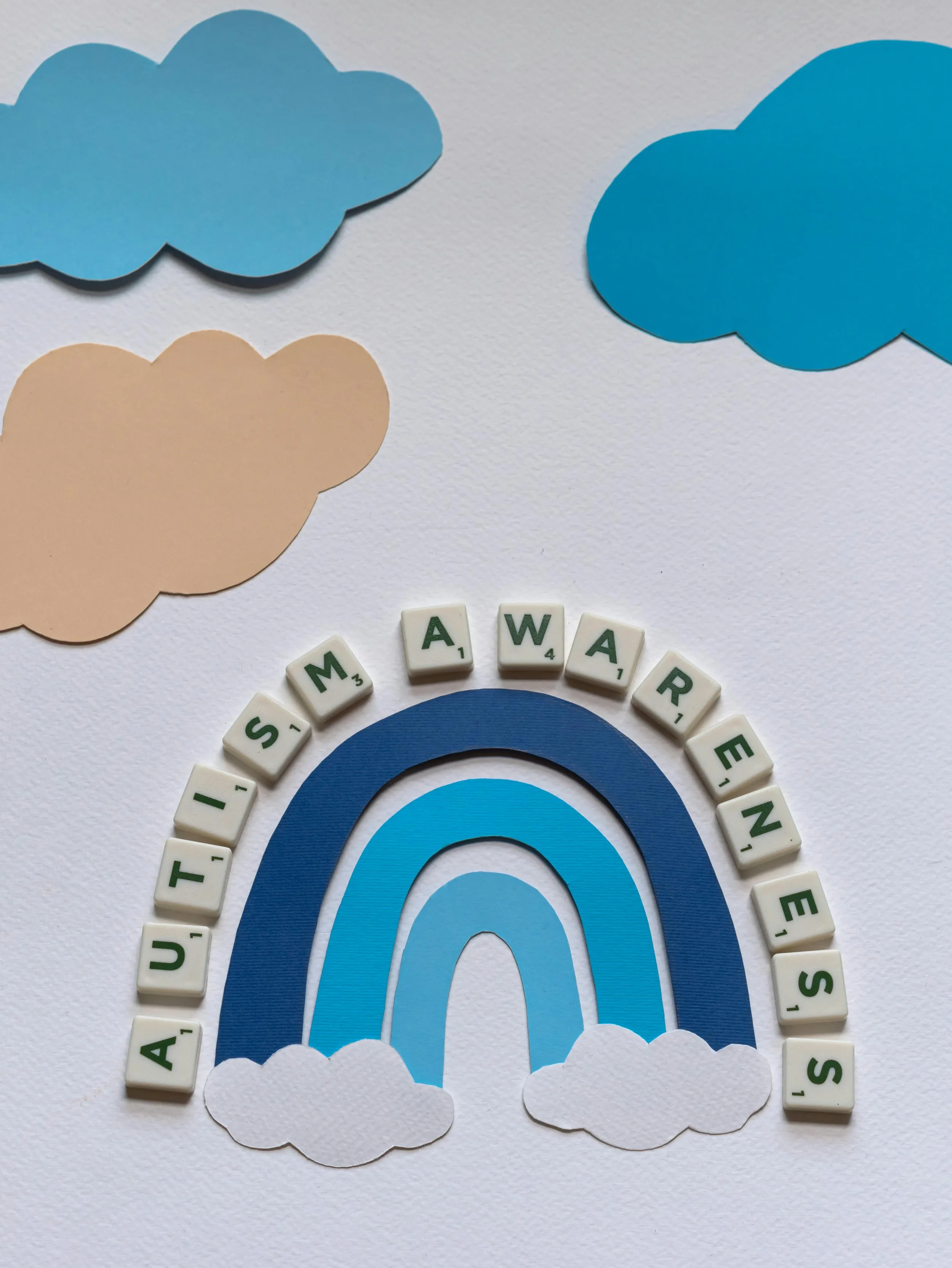 Autism Awareness with a blue rainbow underneath