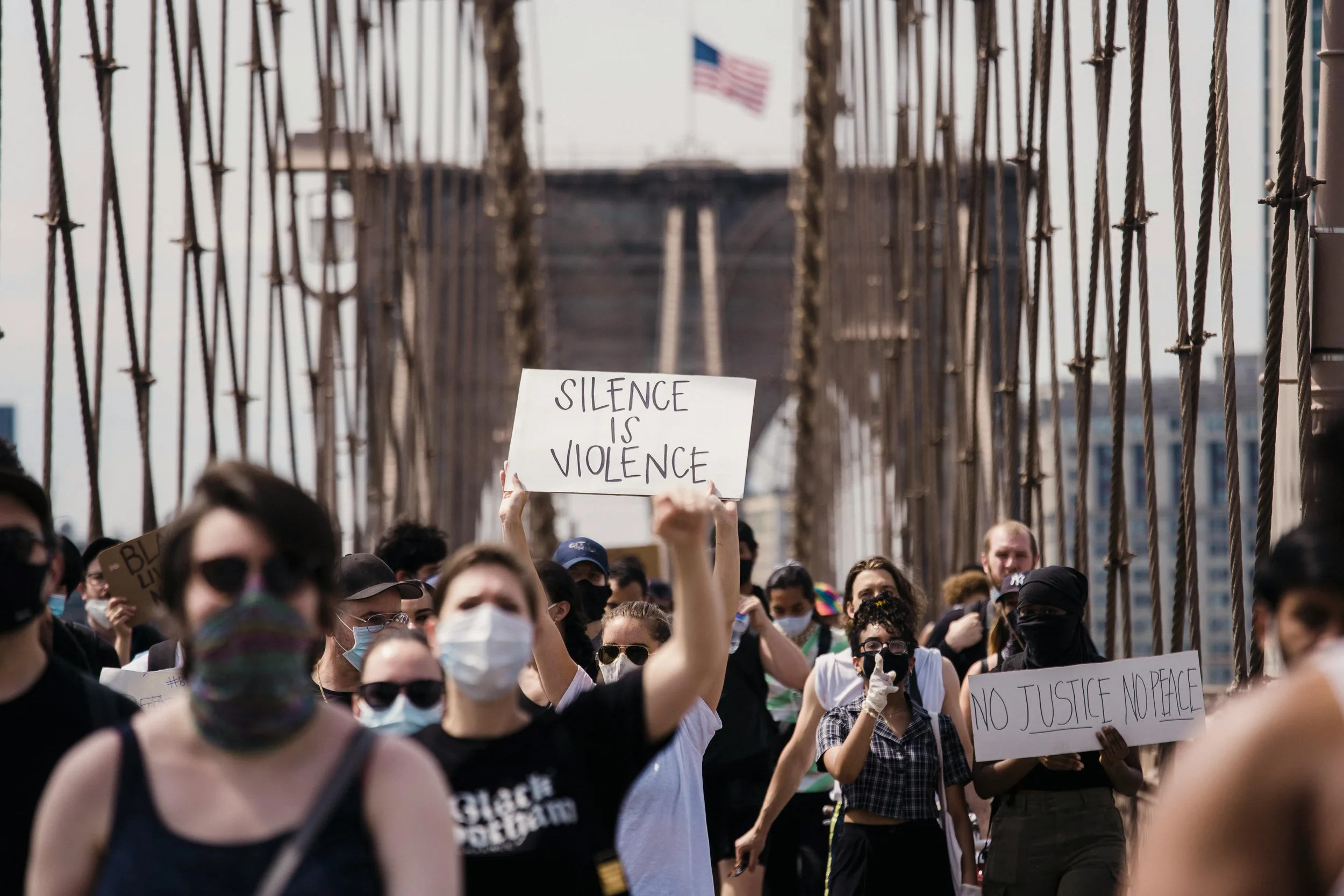 group of protestors walking on the Brooklyn Bridge