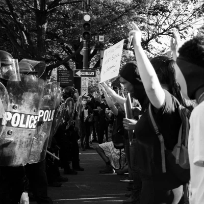 Black and white image of police line with riot gear at a protest