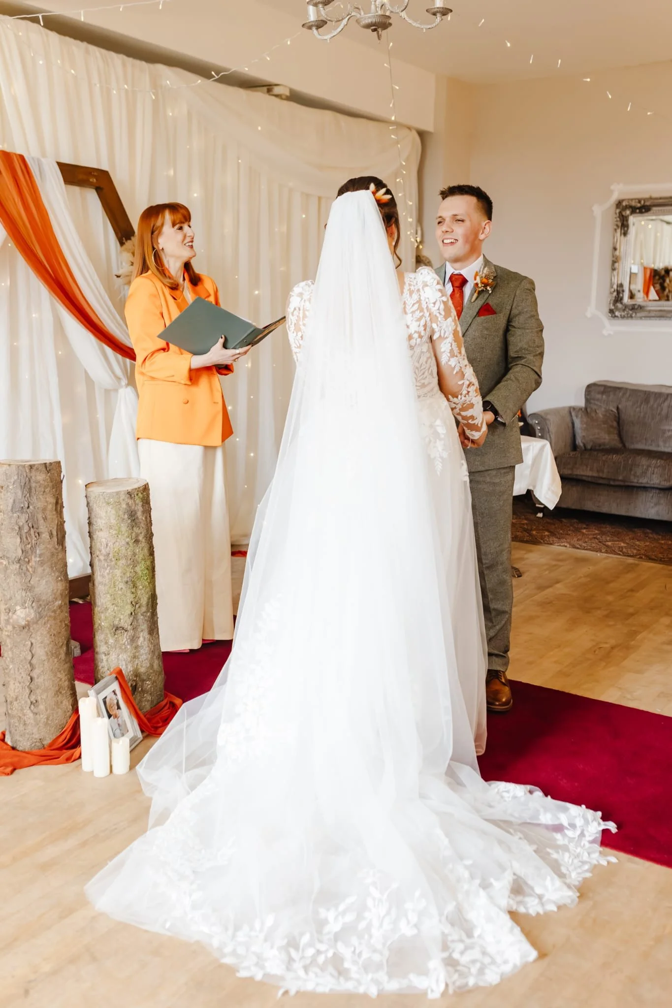 Close-up of a newlywed couple holding hands near wedding flowers, showing wedding rings on their fingers.