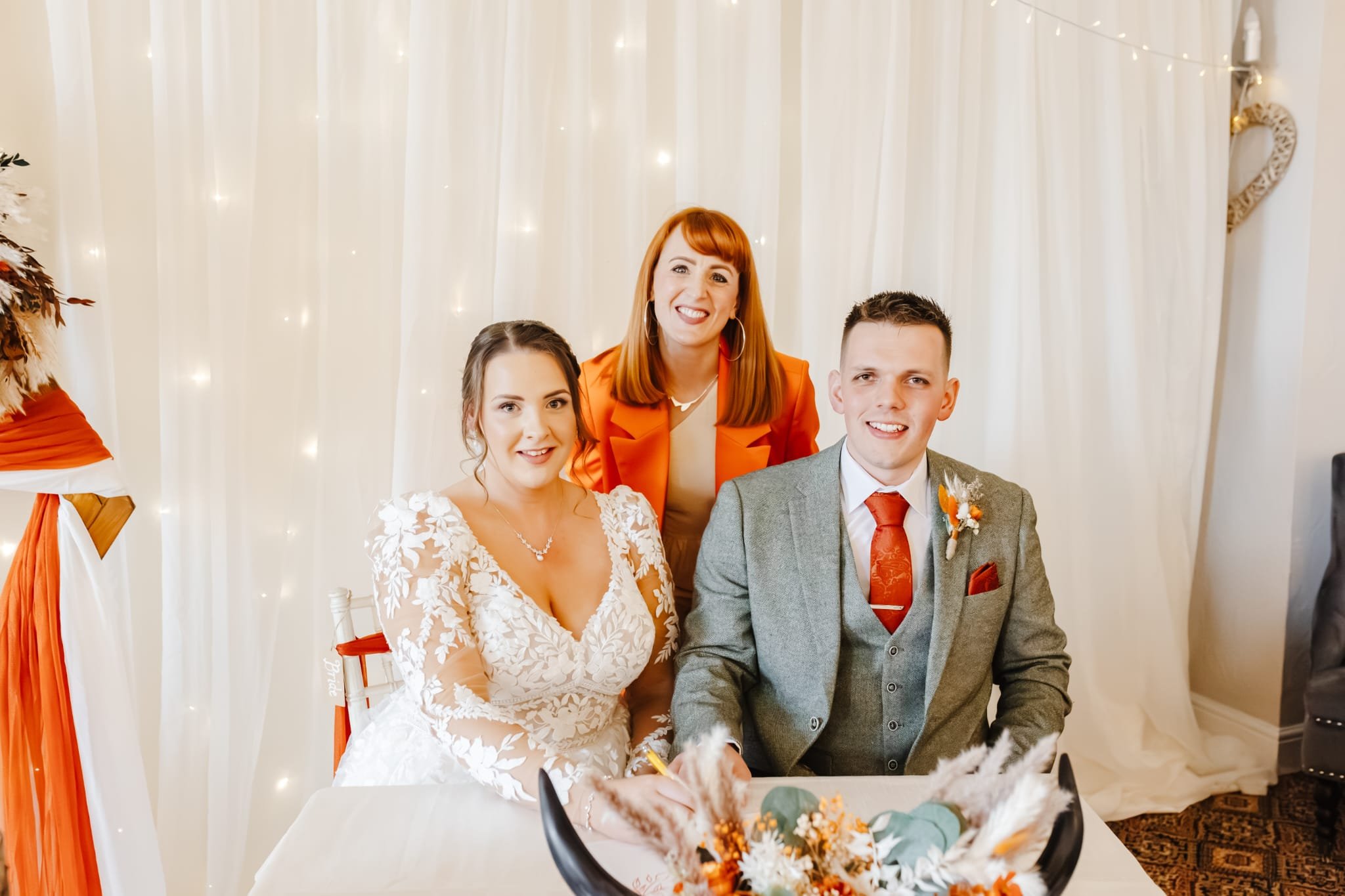 Laurie’s customers, Mariana and Carmen holding hands on a green lawn on their wedding day.