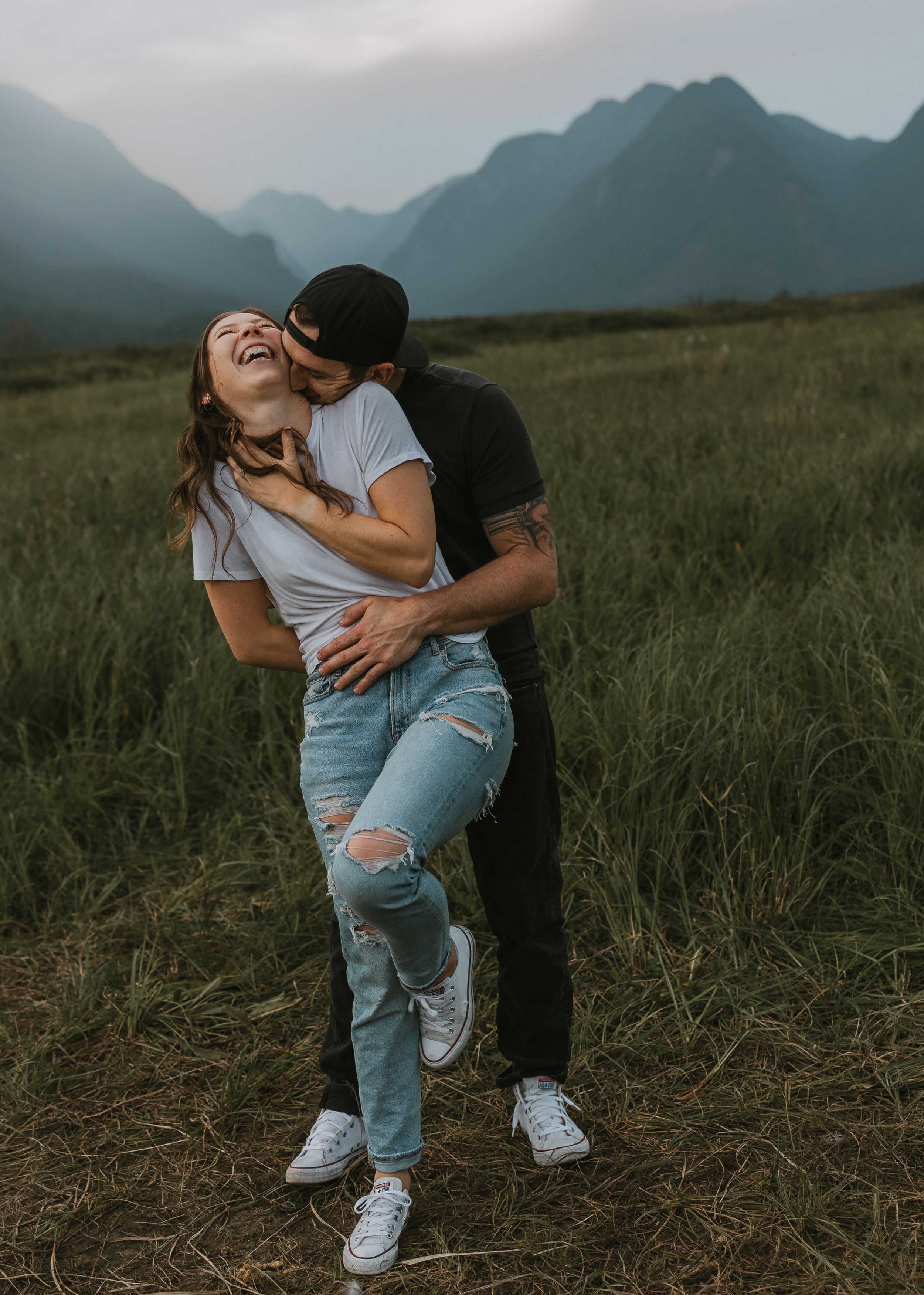Couple laughing and playfully tickling each other outdoors in the mountains of Pitt Meadows, BC, photographed by Alberta & BC lifestyle photographer Shannon Boyd