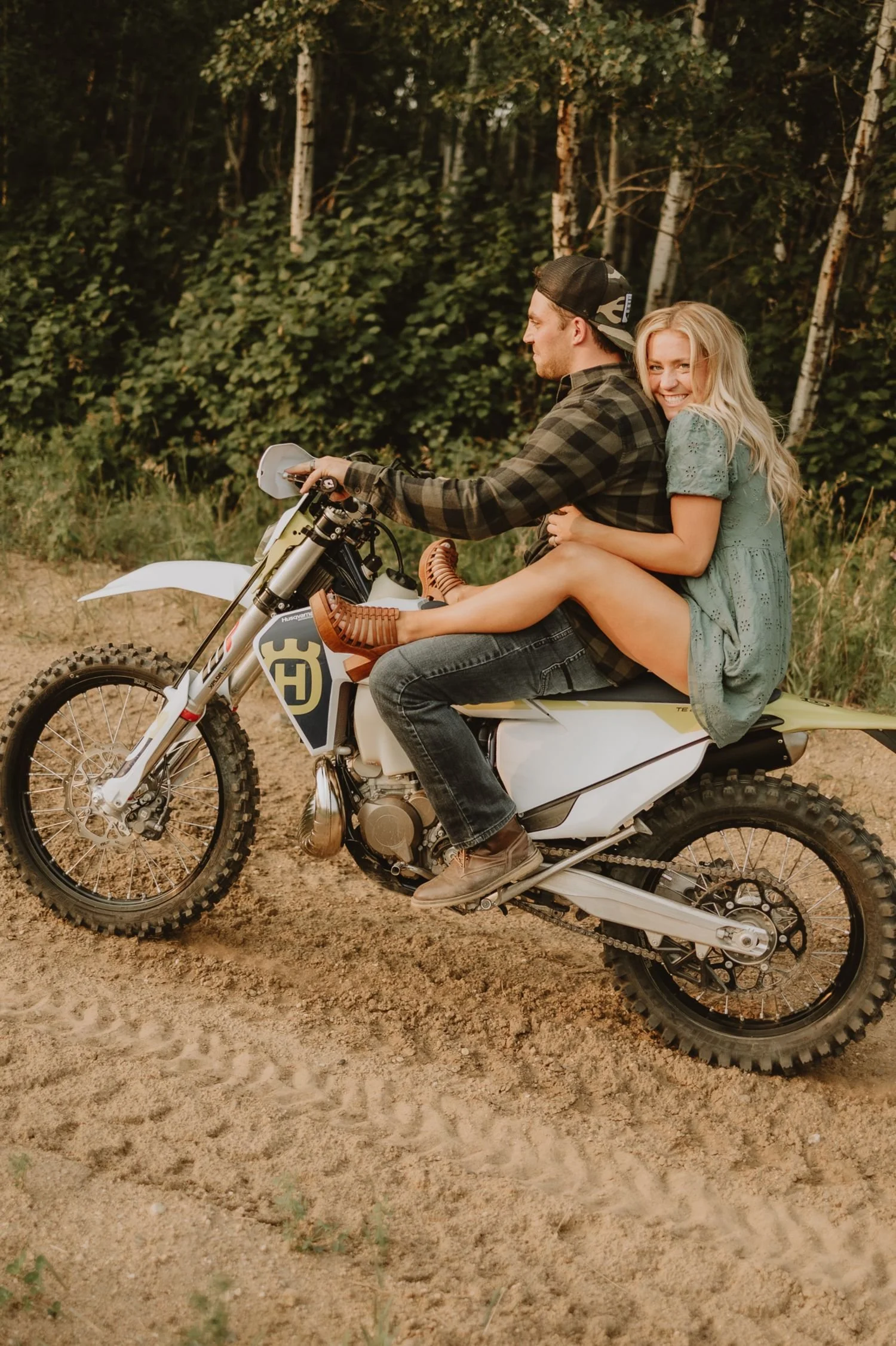 Couple riding off together on a dirt bike during an adventure session, photographed by Alberta & BC lifestyle photographer Shannon Boyd