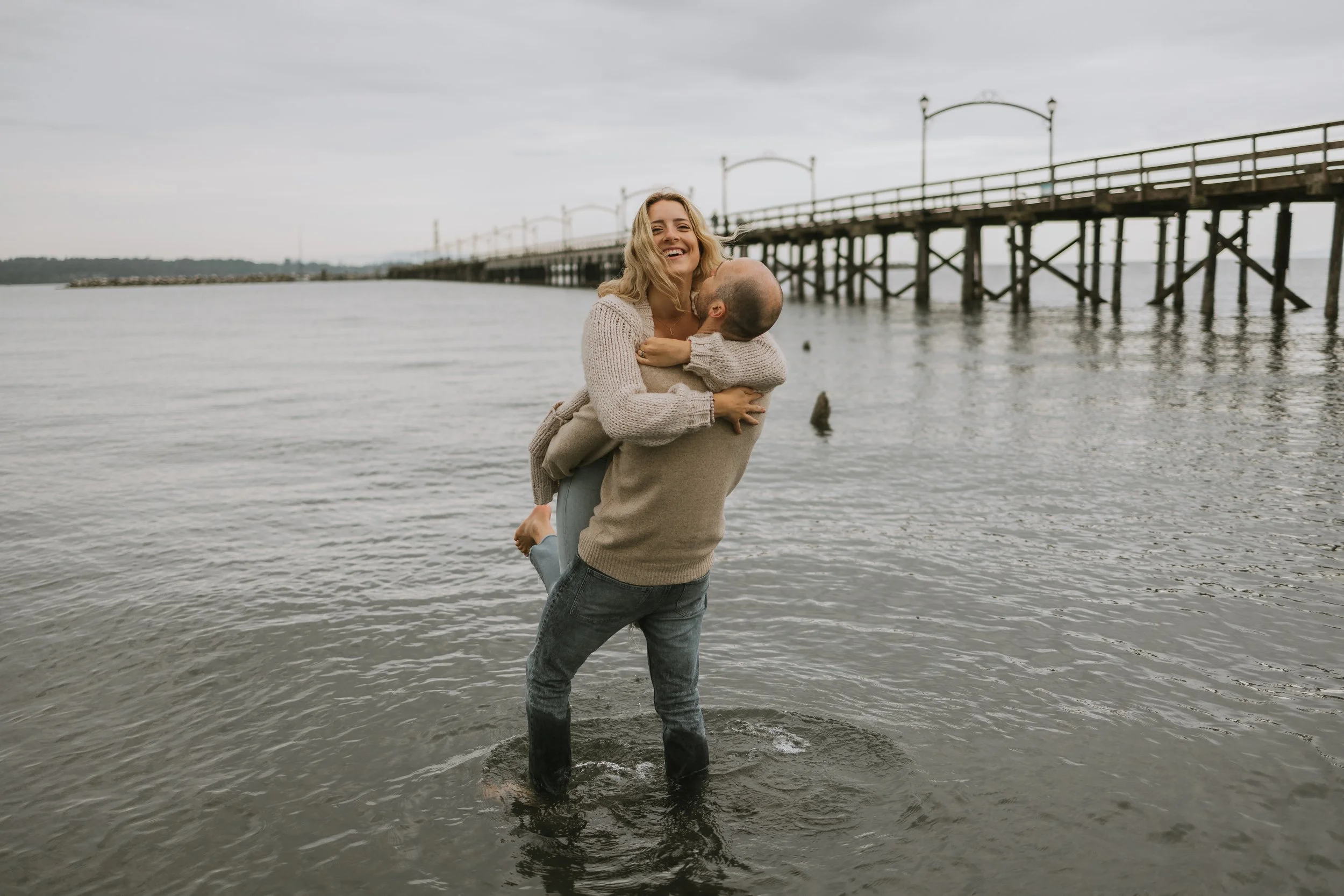 Couple playing in the water during their engagement session at White Rock Beach, British Columbia, photographed by Alberta & BC engagement photographer Shannon Boyd