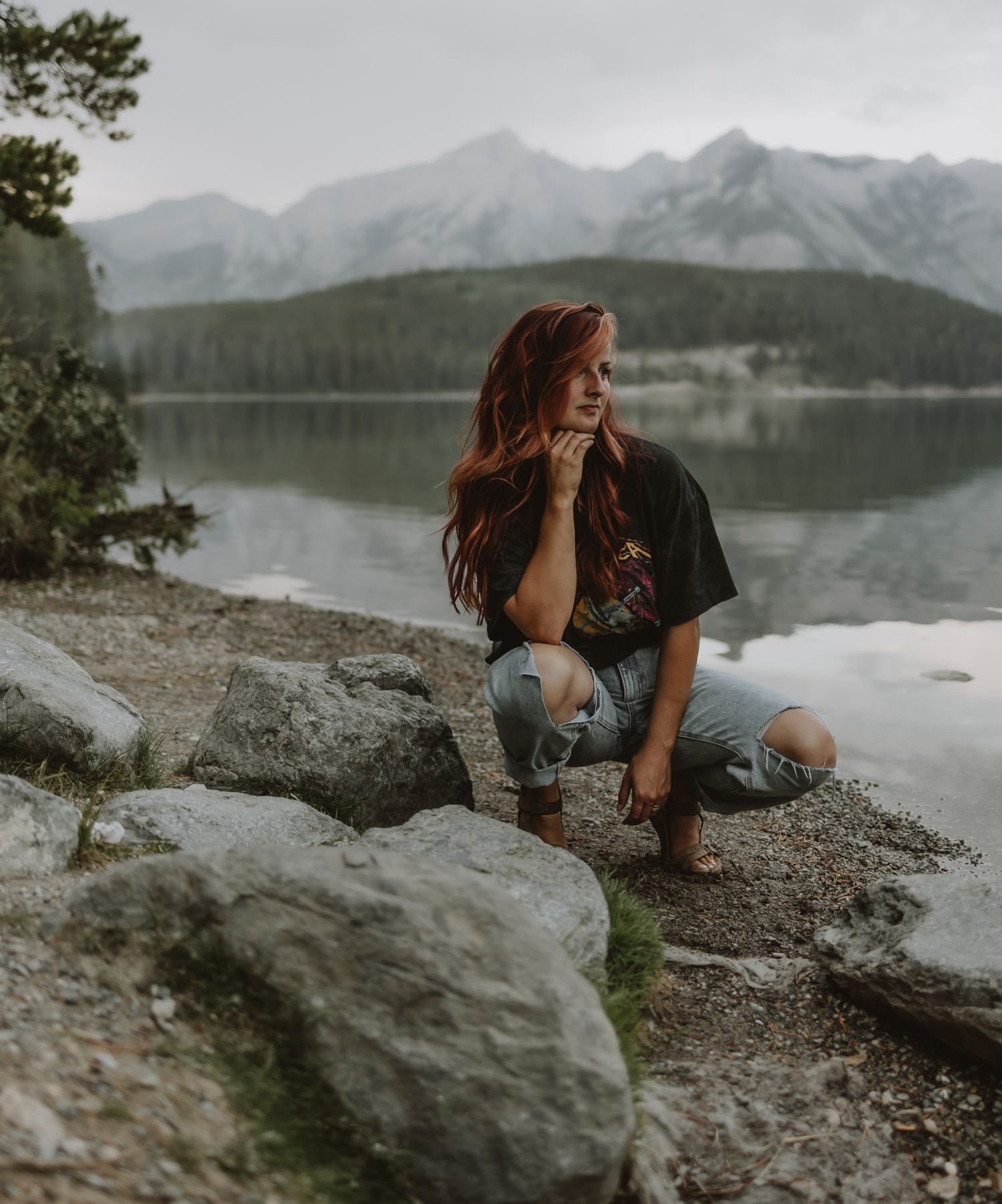Photographer Shannon Boyd standing by the water at Lake Minnewanka in Banff, Alberta, captured during a self-portrait session