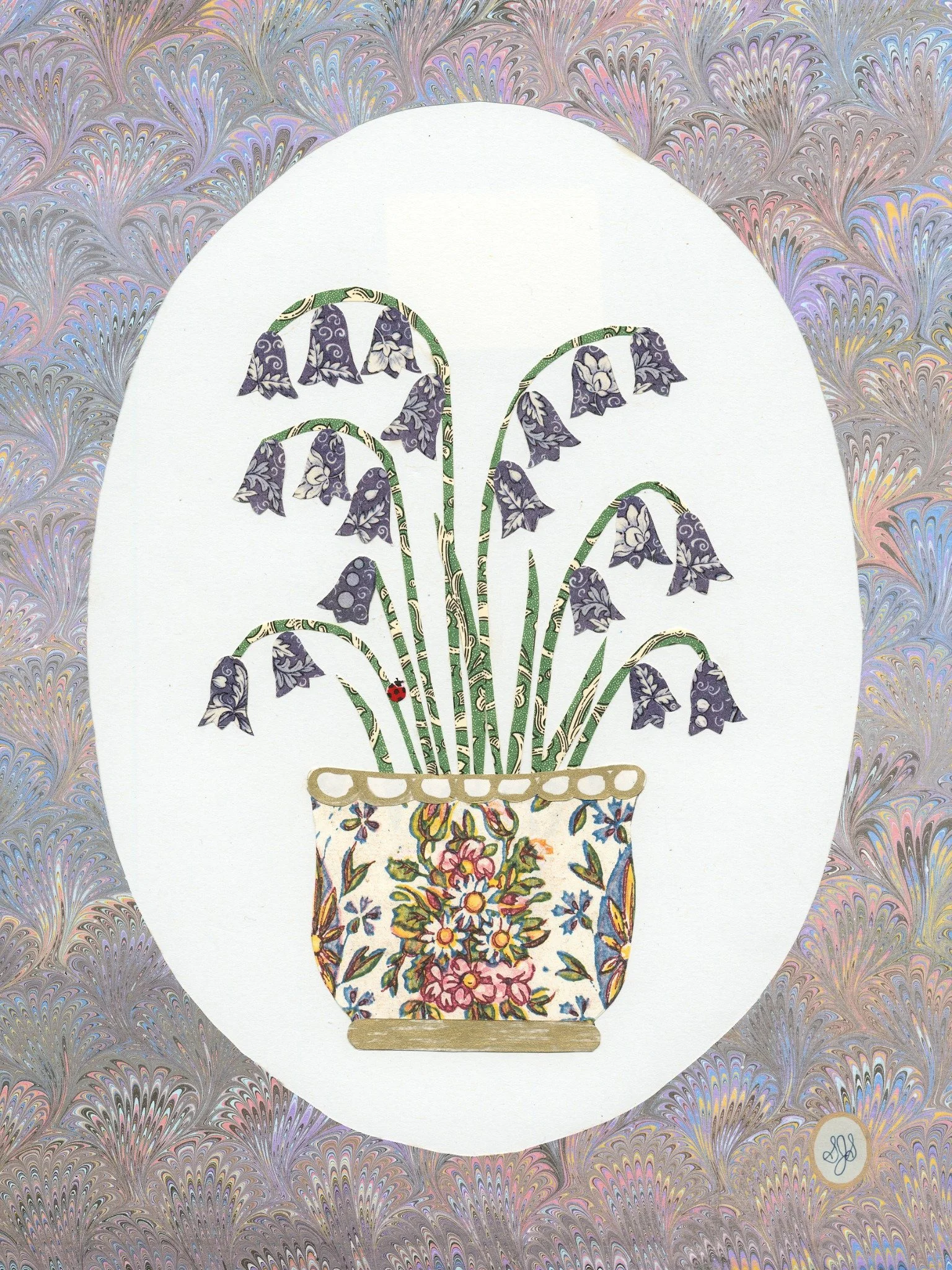 Purple bluebells in multi-color vase with purple circular border