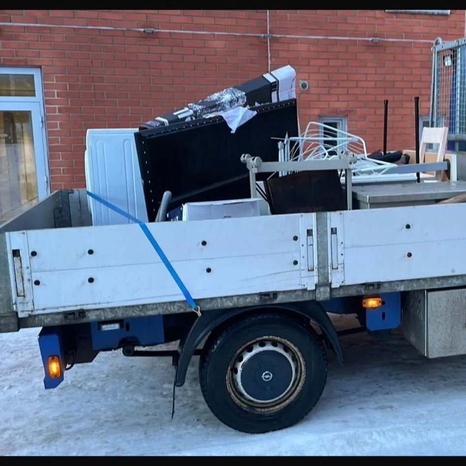 Täynnä jätesäkkejä, huonekaluja ja kodinelektroniikkaa täytetyllä peltikärryllä.