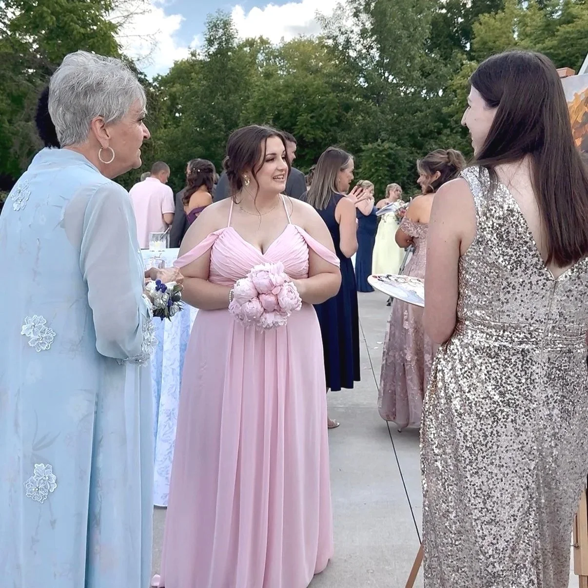 Wedding guests talking with Twin Cities live wedding painter during reception
