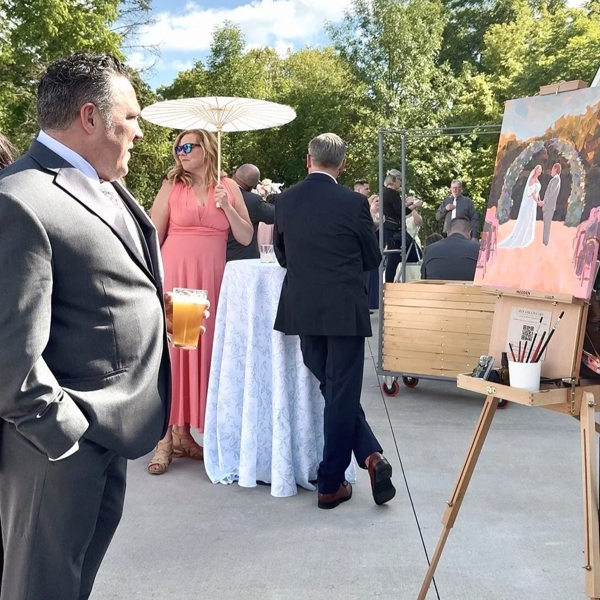 Guest viewing live wedding painting on easel during Green Bay wedding reception