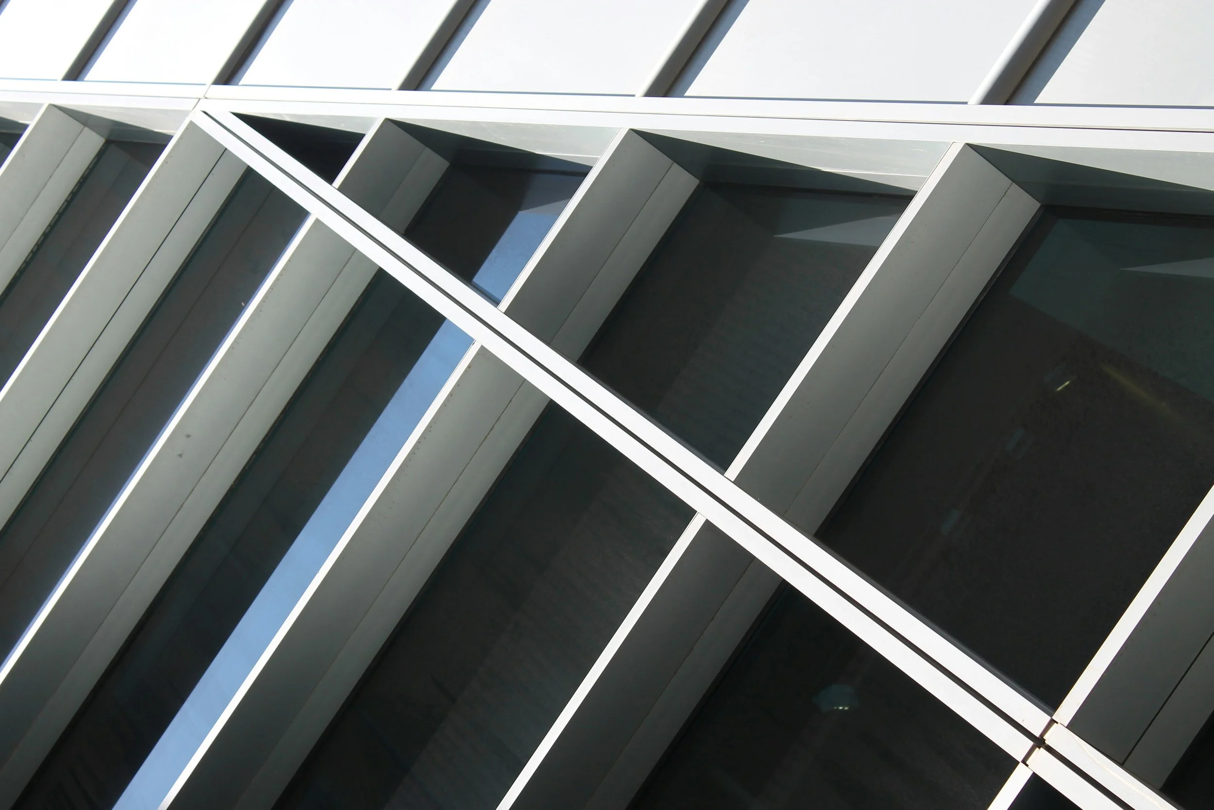 Close-up of a modern building facade with angular concrete and glass panels.