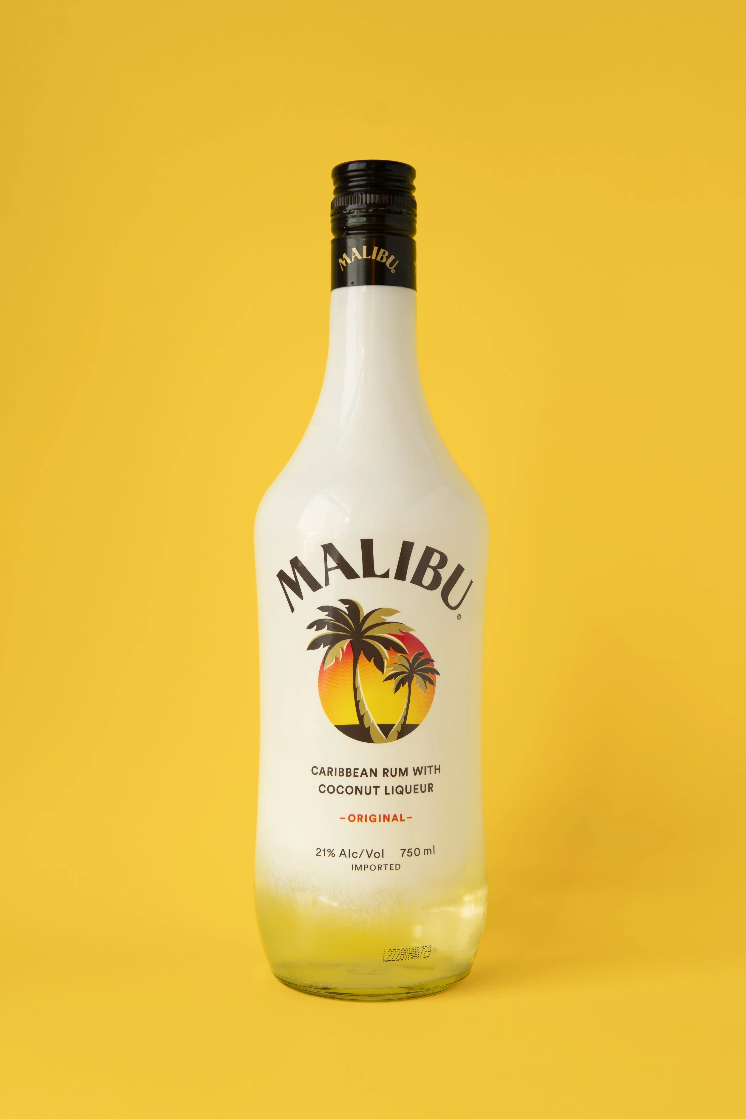 A Malibu Caribbean rum bottle with coconut liqueur on a yellow background.