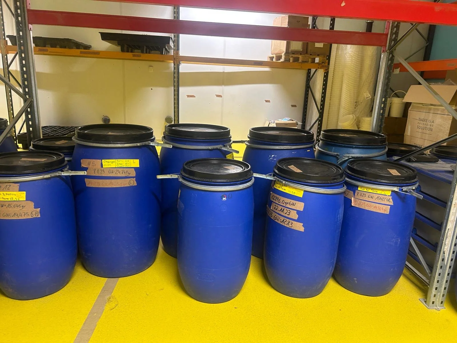 Two glass jars filled with cannabis buds placed on a white surface in a bright room.