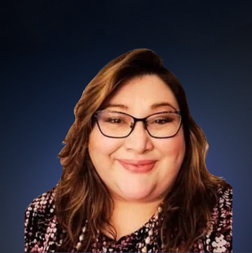 A woman with wavy brown hair, glasses, and a patterned top smiling at the camera.