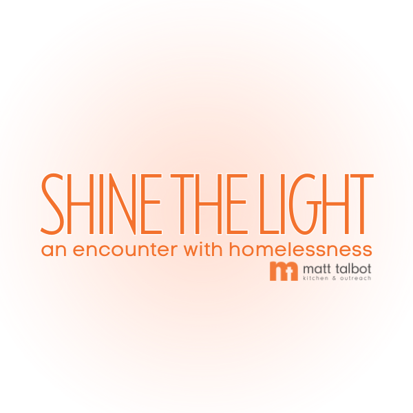 Pink circular sign with the text "SHINE THE LIGHT" and "an encounter with homelessness," featuring the Matt Talbot Kitchen & Outreach logo.