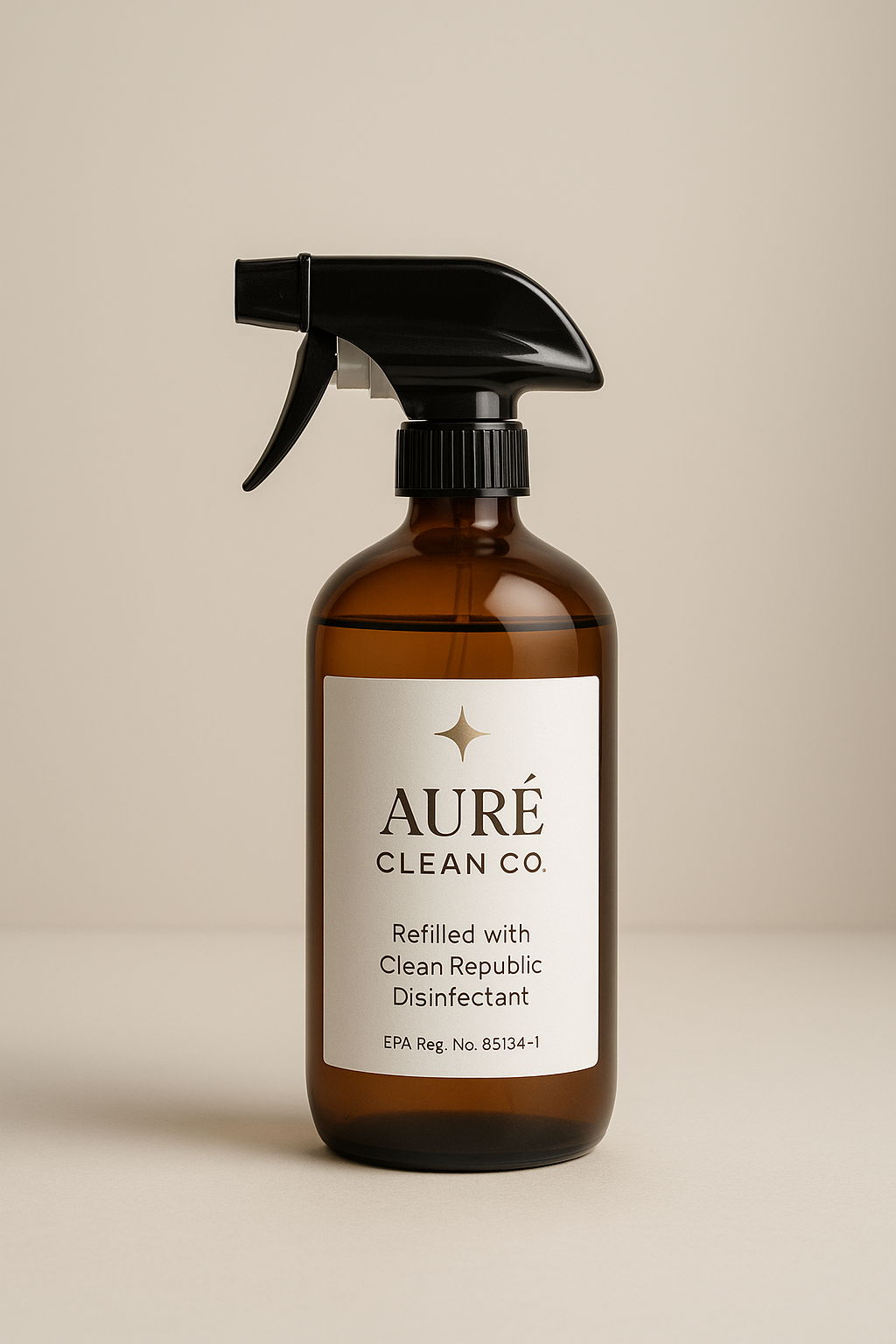 Amber glass spray bottle labeled 'AURÉ CLEAN CO. Refilled with Clean Republic Disinfectant' against a neutral background.