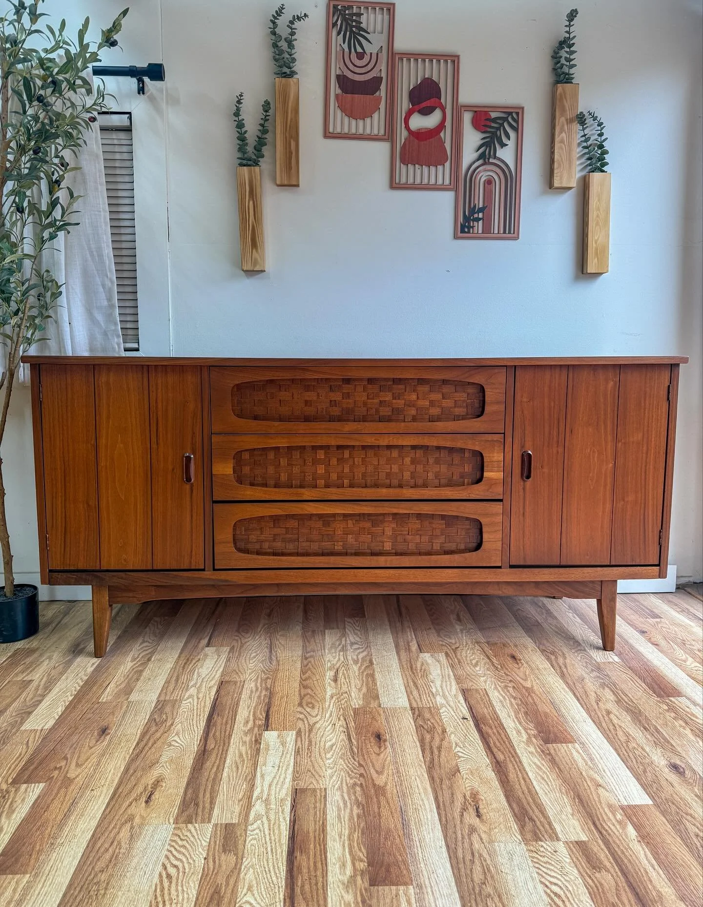 Mid century modern MCM vintage walnut credenza/sideboard/tv stand. Circa 1960&rsquo;s. Features beautiful walnut wood grains, tapered mid century legs, three dove-tailed center drawers w/ a really cool rattan pattern, and two doors that expose shelvi