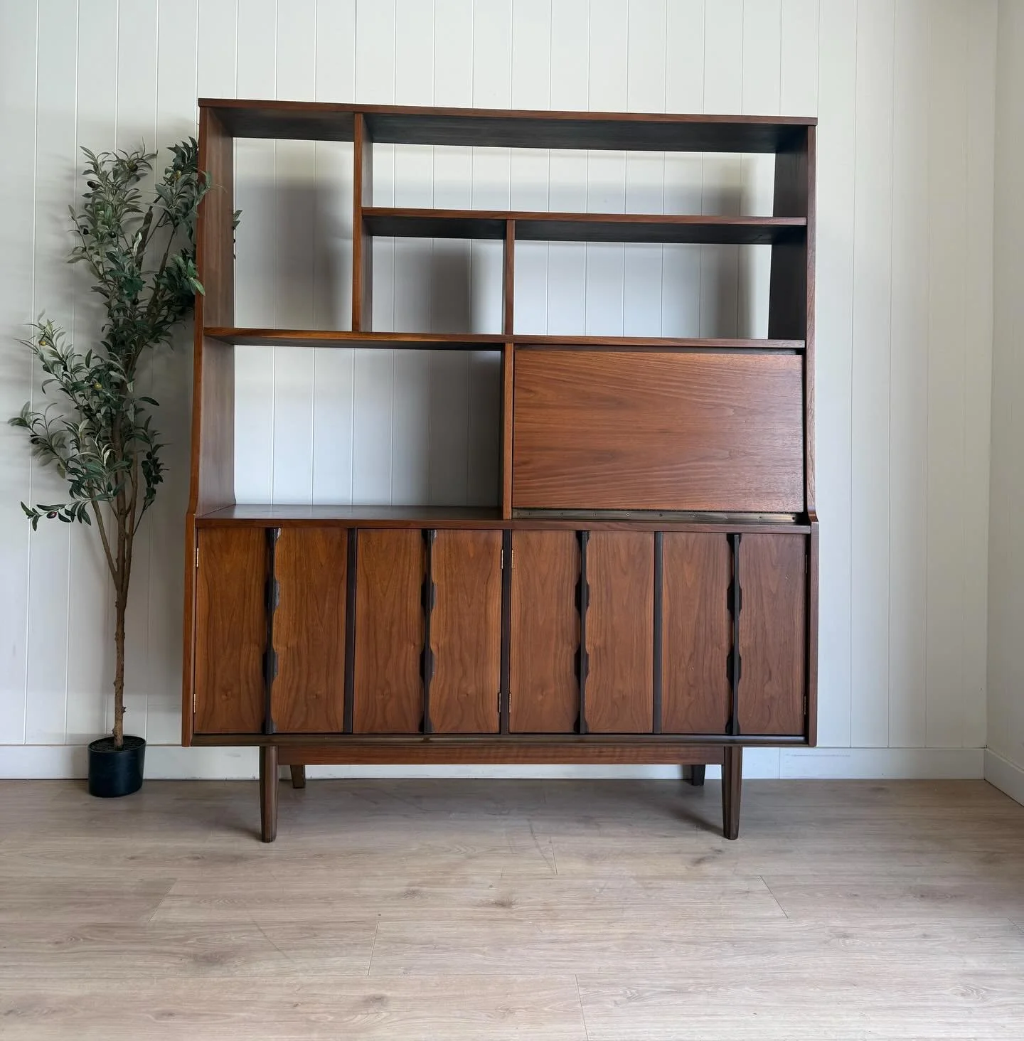 (SOLD) MCM mid century modern vintage walnut floating bookshelf/room divider. Circa 1960&rsquo;s. Features beautiful walnut wood grains, an assortment of shelves, a drop down bar cabinet, and even more storage areas behind the bottom four doors. Rest