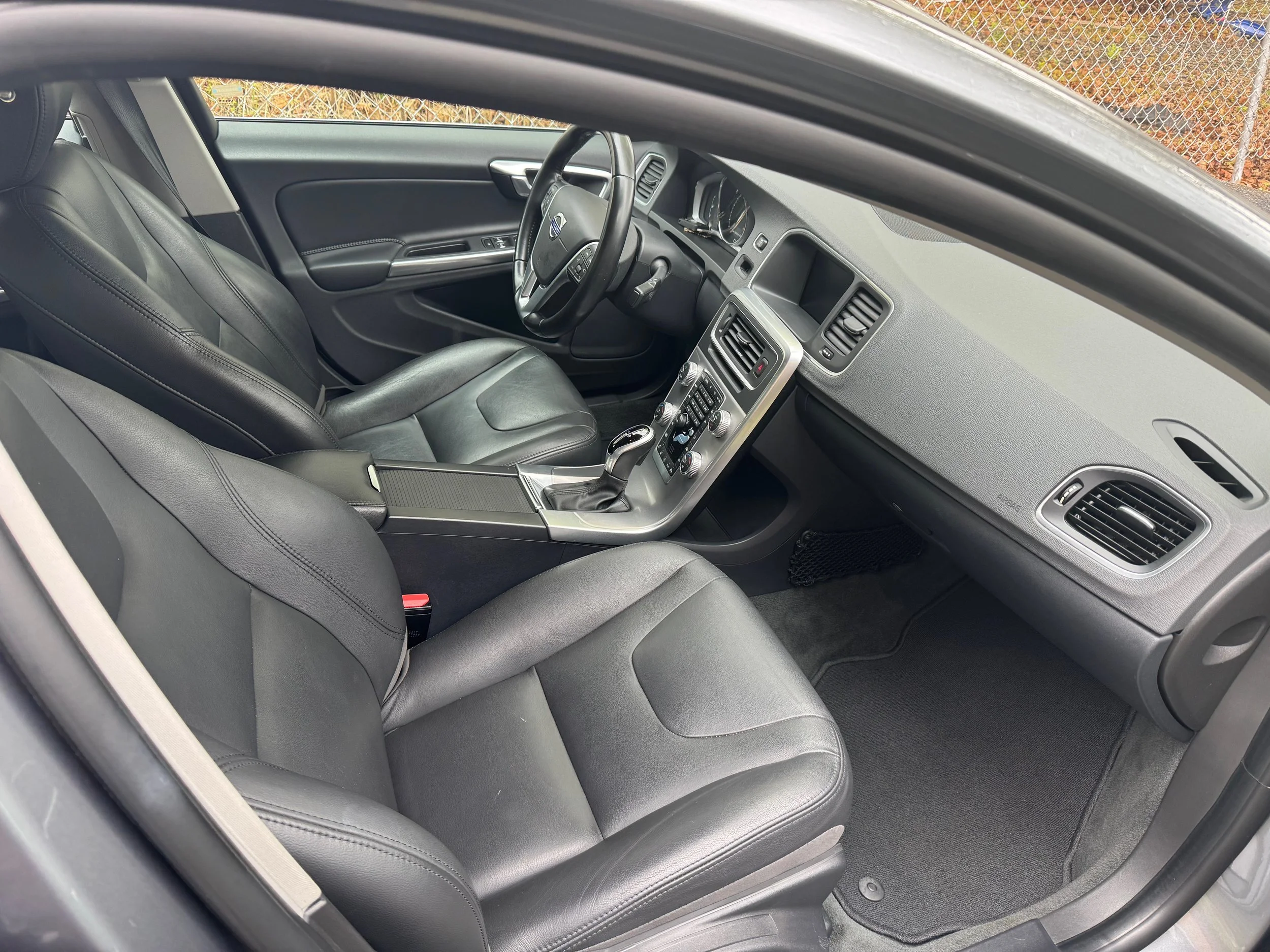 Interior of a modern car with black leather seats, dashboard, and center console with various controls.