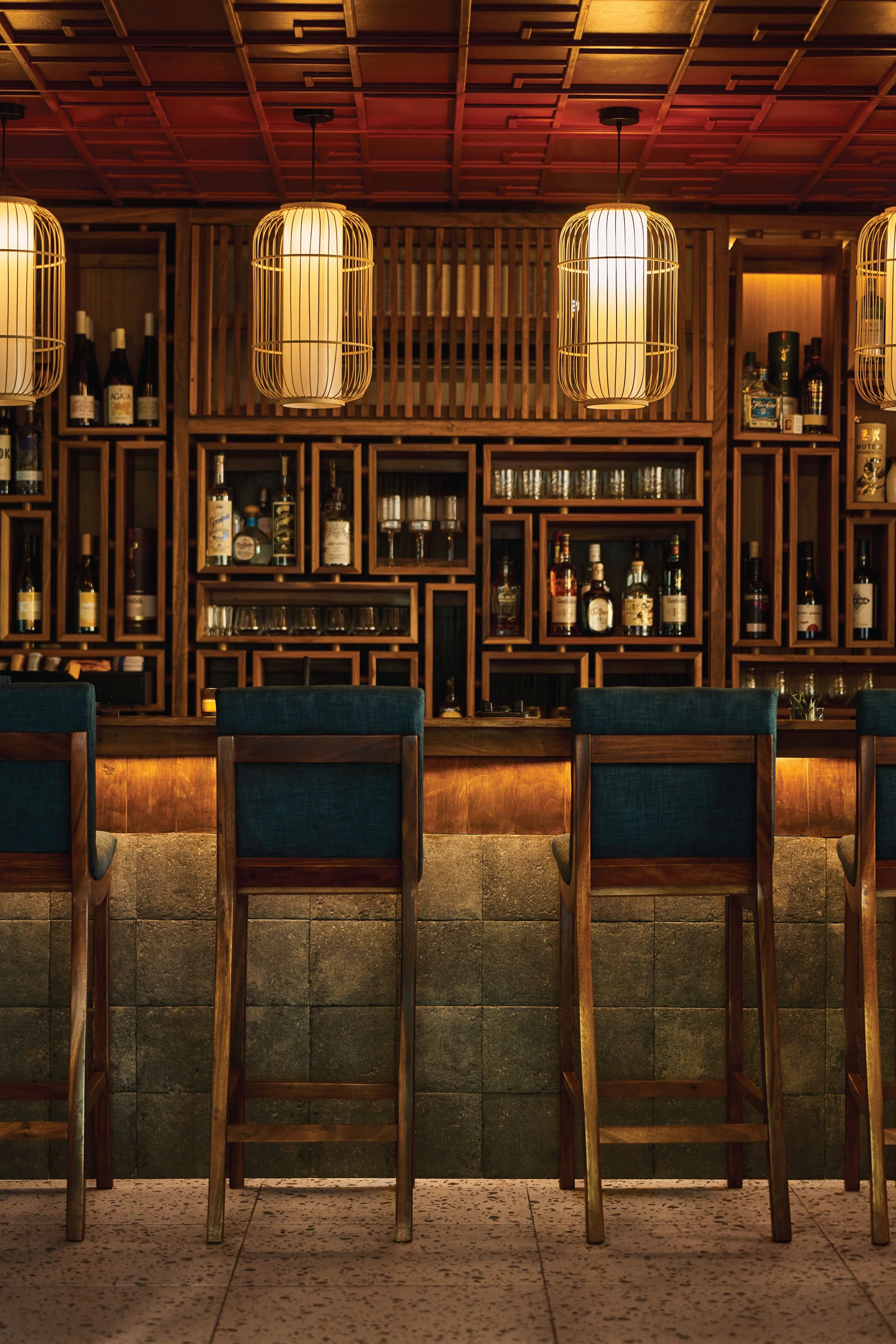 Teal leather banquette and wooden armchairs below a geisha mural, Satori