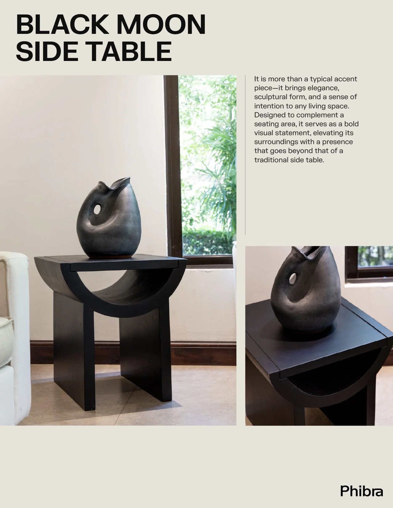 Photo of a black side table with a semi-circular bowl-shaped design, placed against a window with green foliage outside, topped with a dark abstract sculpture.
