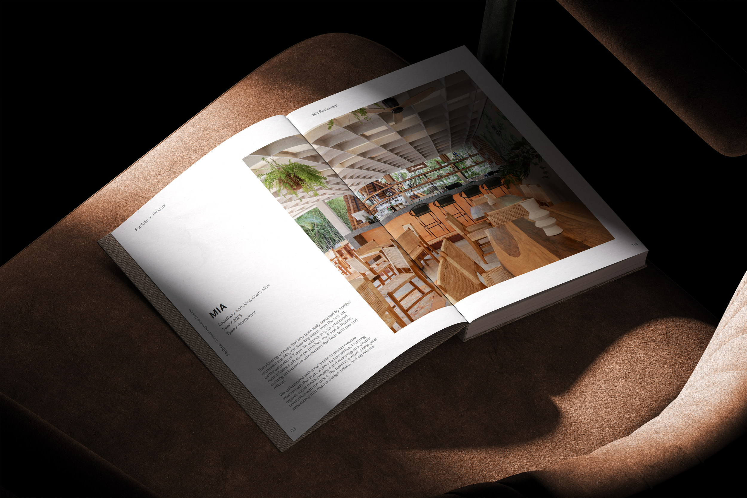Phibra portfolio open on a velvet chair, showing a restaurant interior