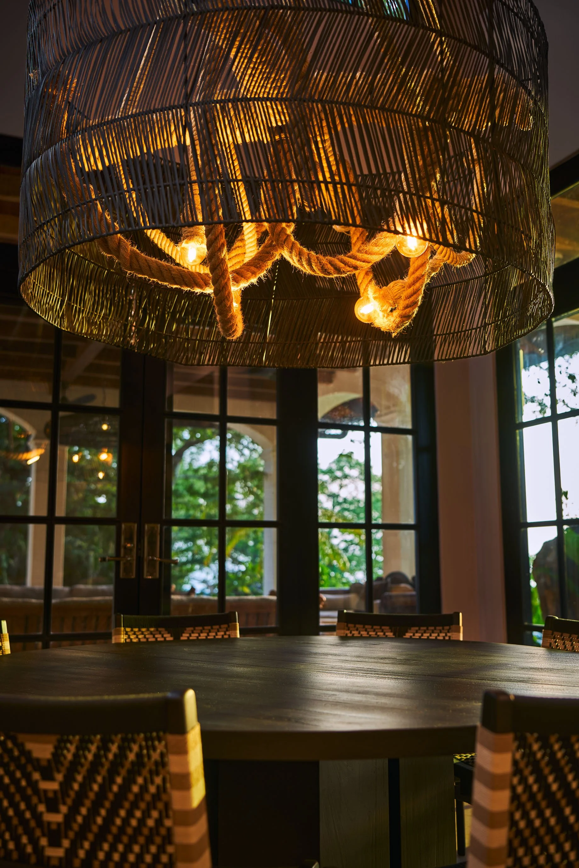 Woven fiber chandelier and arched windows with tropical views, Casa Ladera