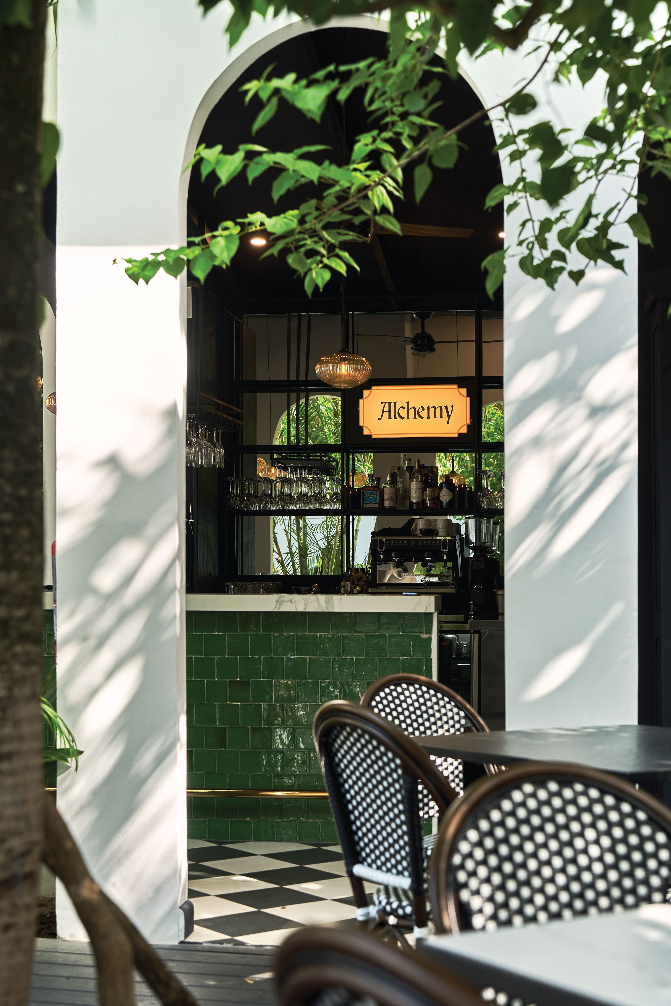 Bar counter in green zellige tile with a white marble top and the Alchemy sign