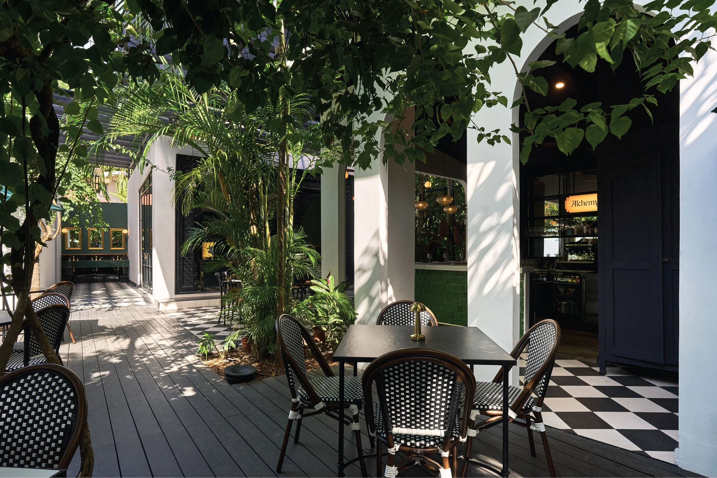 Courtyard with a checkered path, bistro tables and lush planting, Casa de Malka Nosara